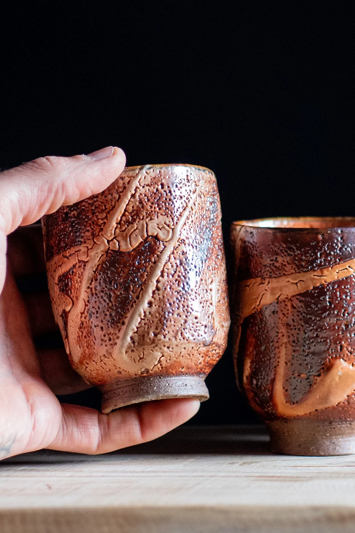 Handmade yunomi cups with Shino glaze featuring crackled textures and soft atmospheric surfaces.