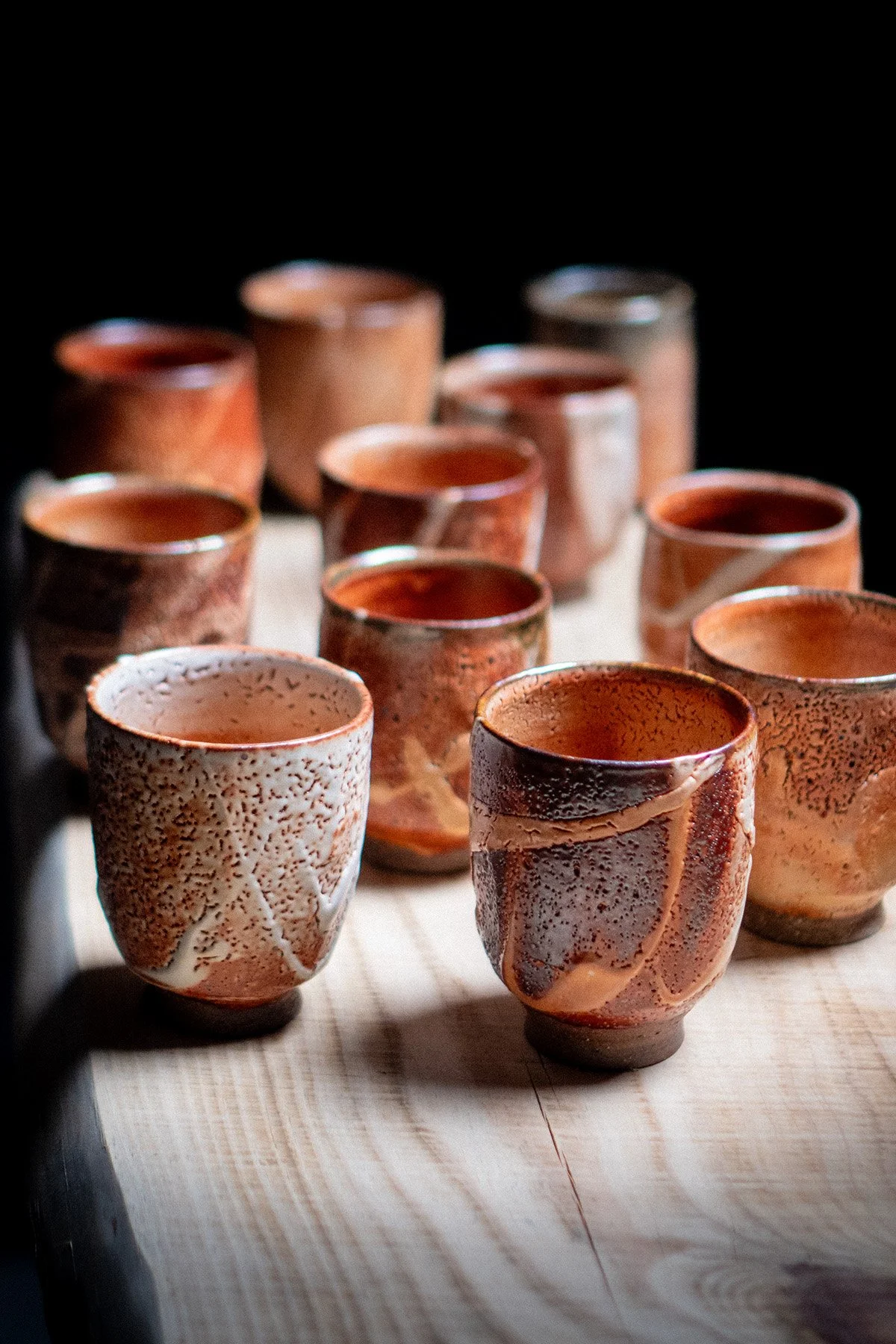 Handmade yunomi cups with Shino glaze featuring crackled textures and soft atmospheric surfaces.