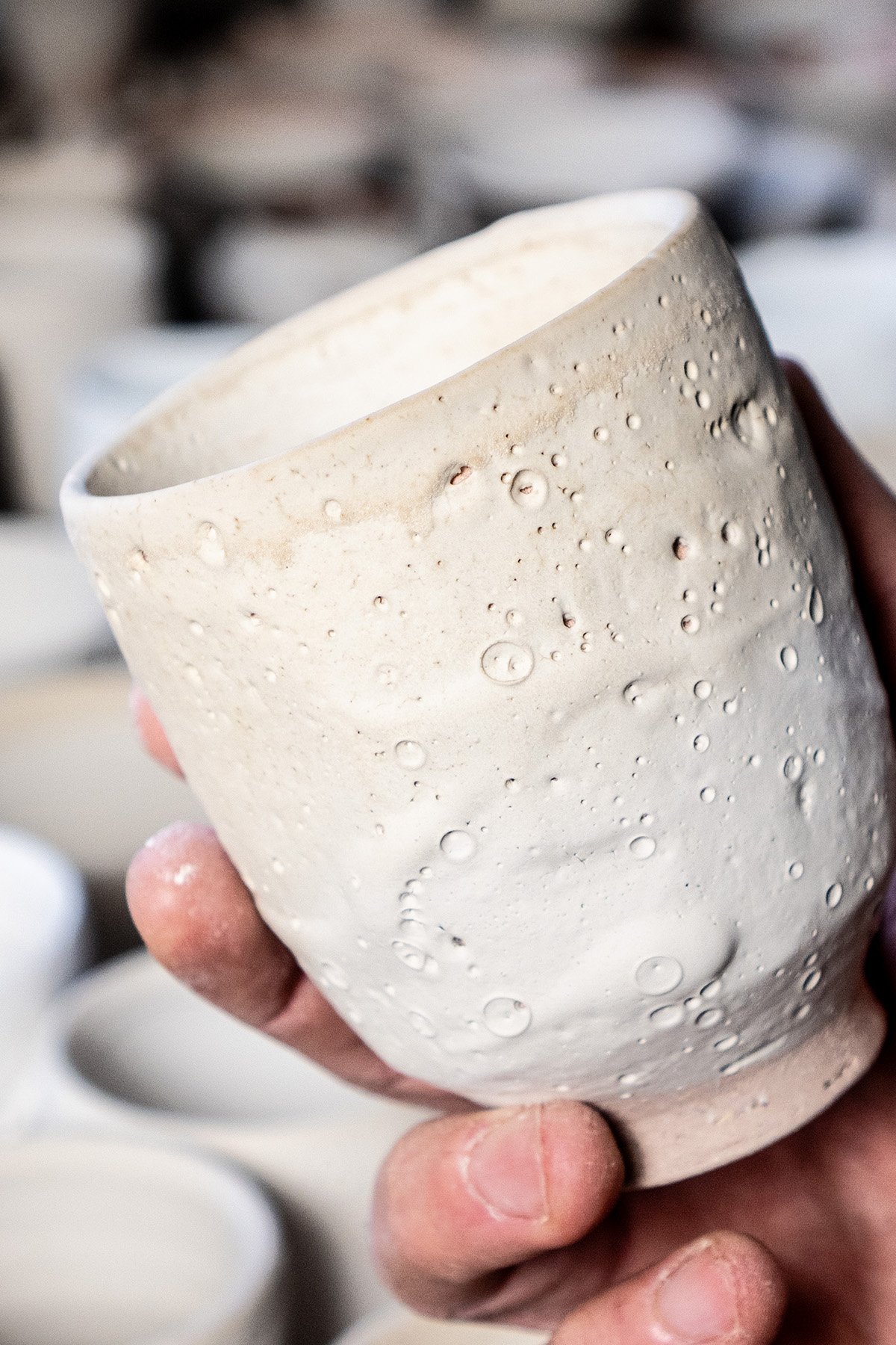Applying Shino glaze by hand before firing in a soda and reduction atmosphere kiln.