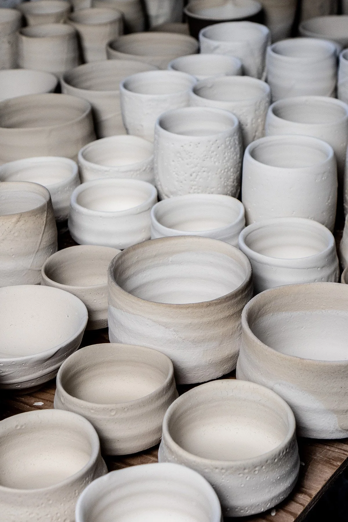 Applying Shino glaze by hand before firing in a soda and reduction atmosphere kiln.
