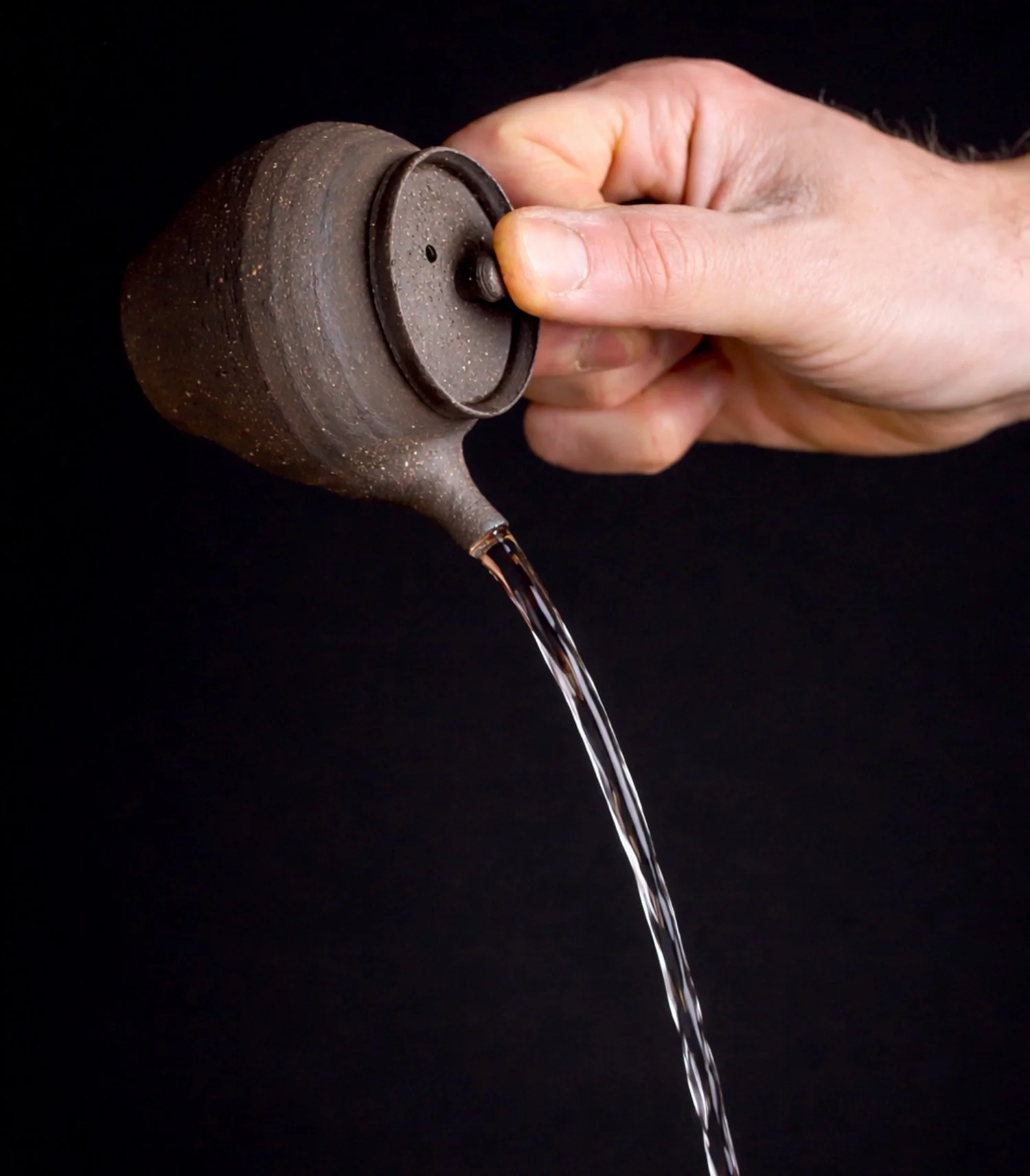 Handmade kyusu teapot pouring tea. House of handmade teaware