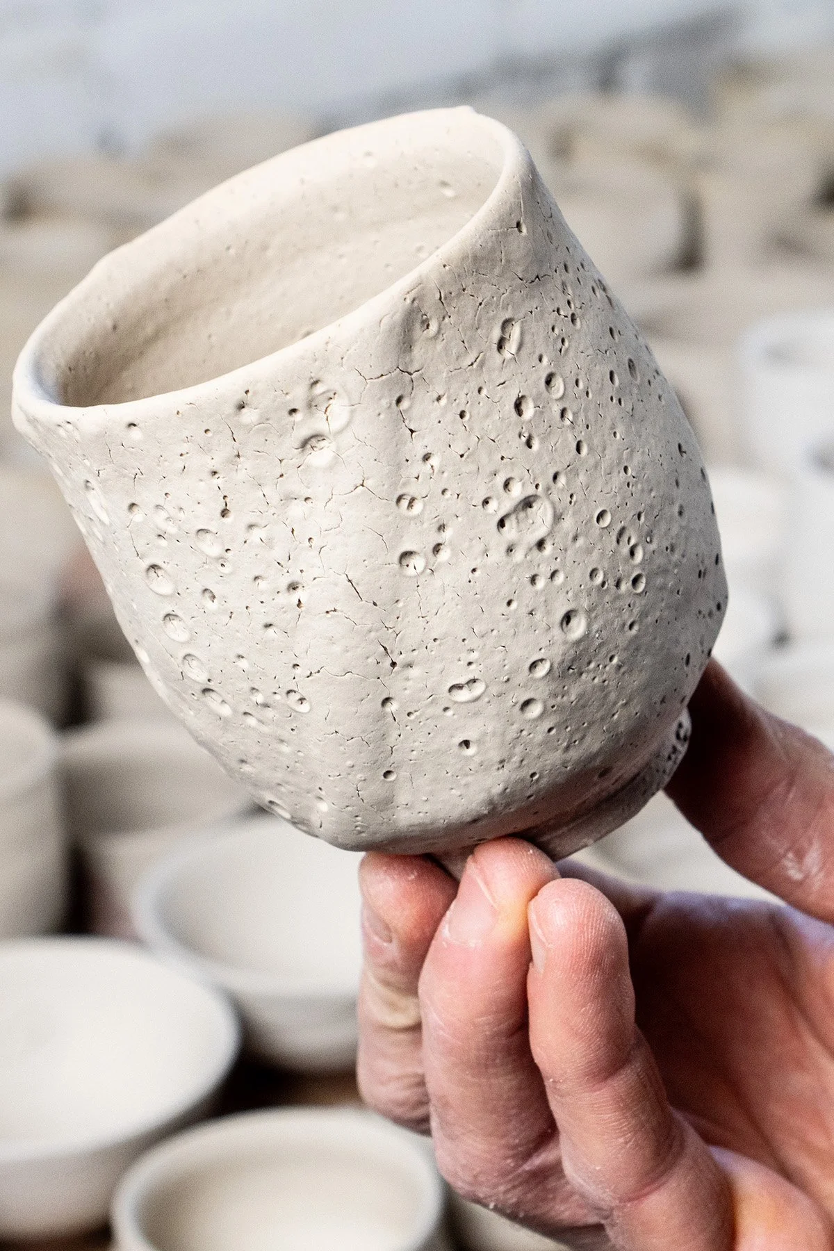Applying Shino glaze by hand before firing in a soda and reduction atmosphere kiln.