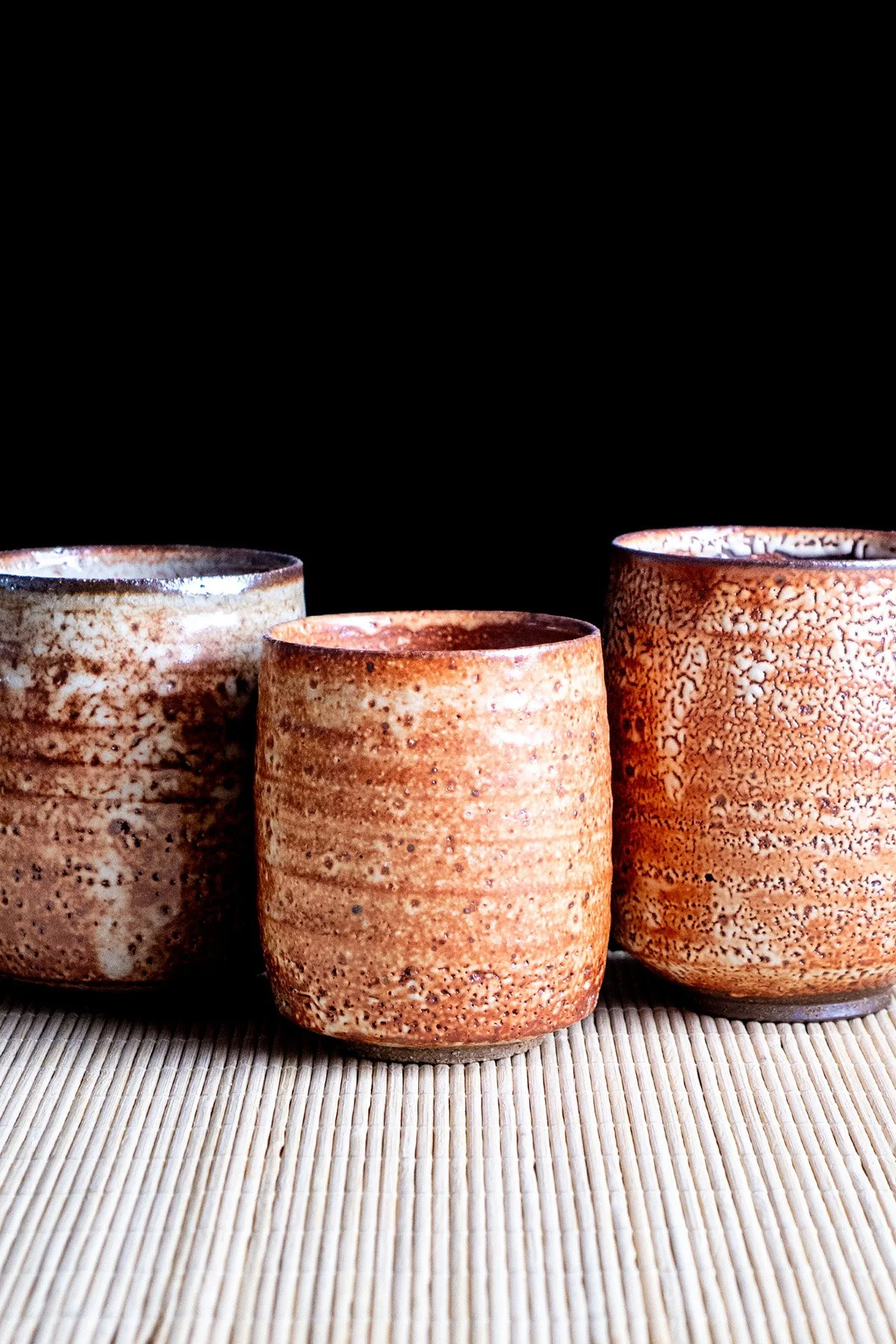 Handmade yunomi cups with Shino glaze featuring crackled textures and soft atmospheric surfaces.