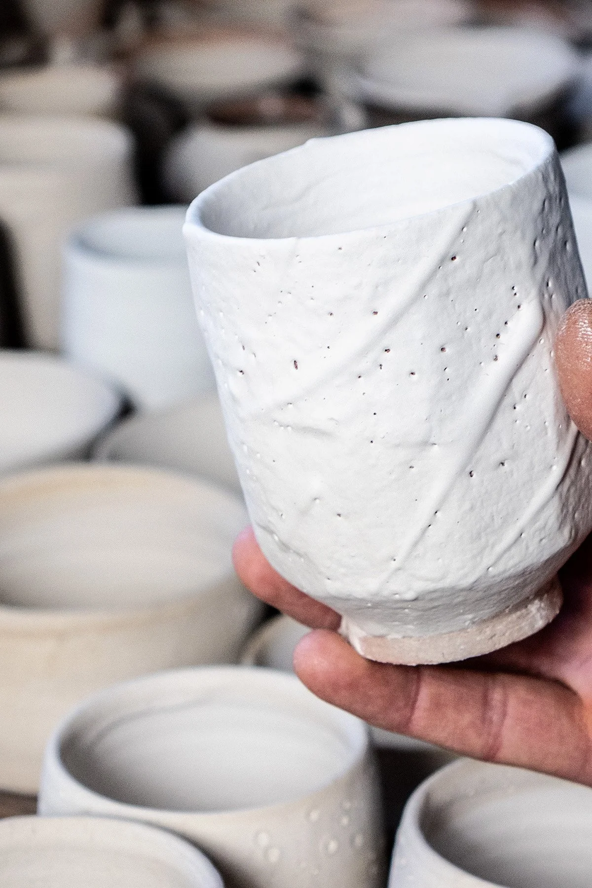 Applying Shino glaze by hand before firing in a soda and reduction atmosphere kiln.