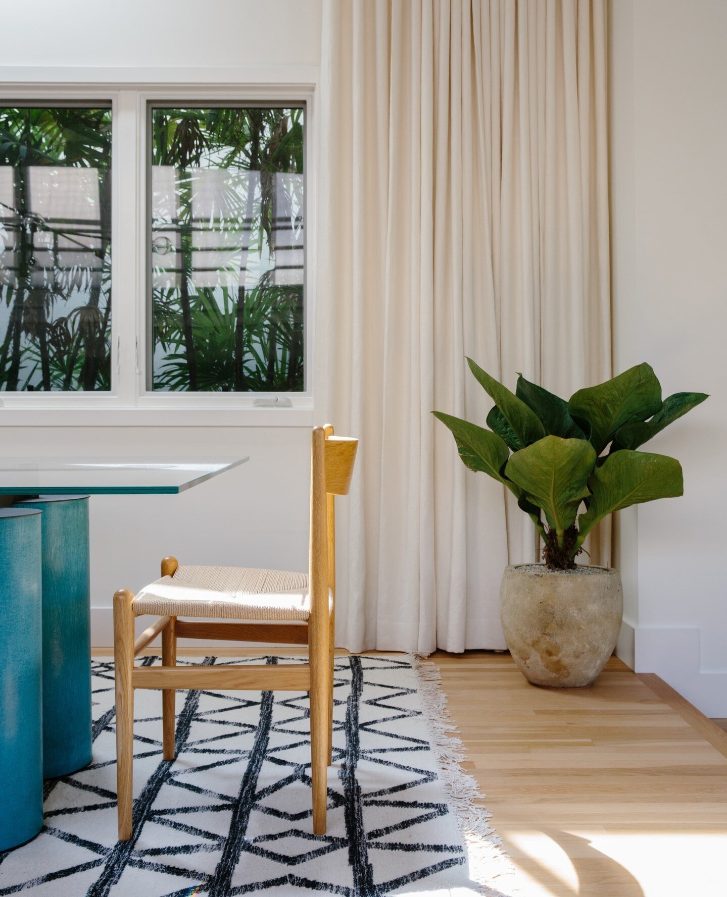 Anyone else struggle to write captions to your posts?⁠
.⁠
I love this fresh combo of Carl Hansen dining chair, custom dining table from the 1980's, a super graphic and modern navy and cream flat weave rug, creamy linen drapes and the tropical plants 