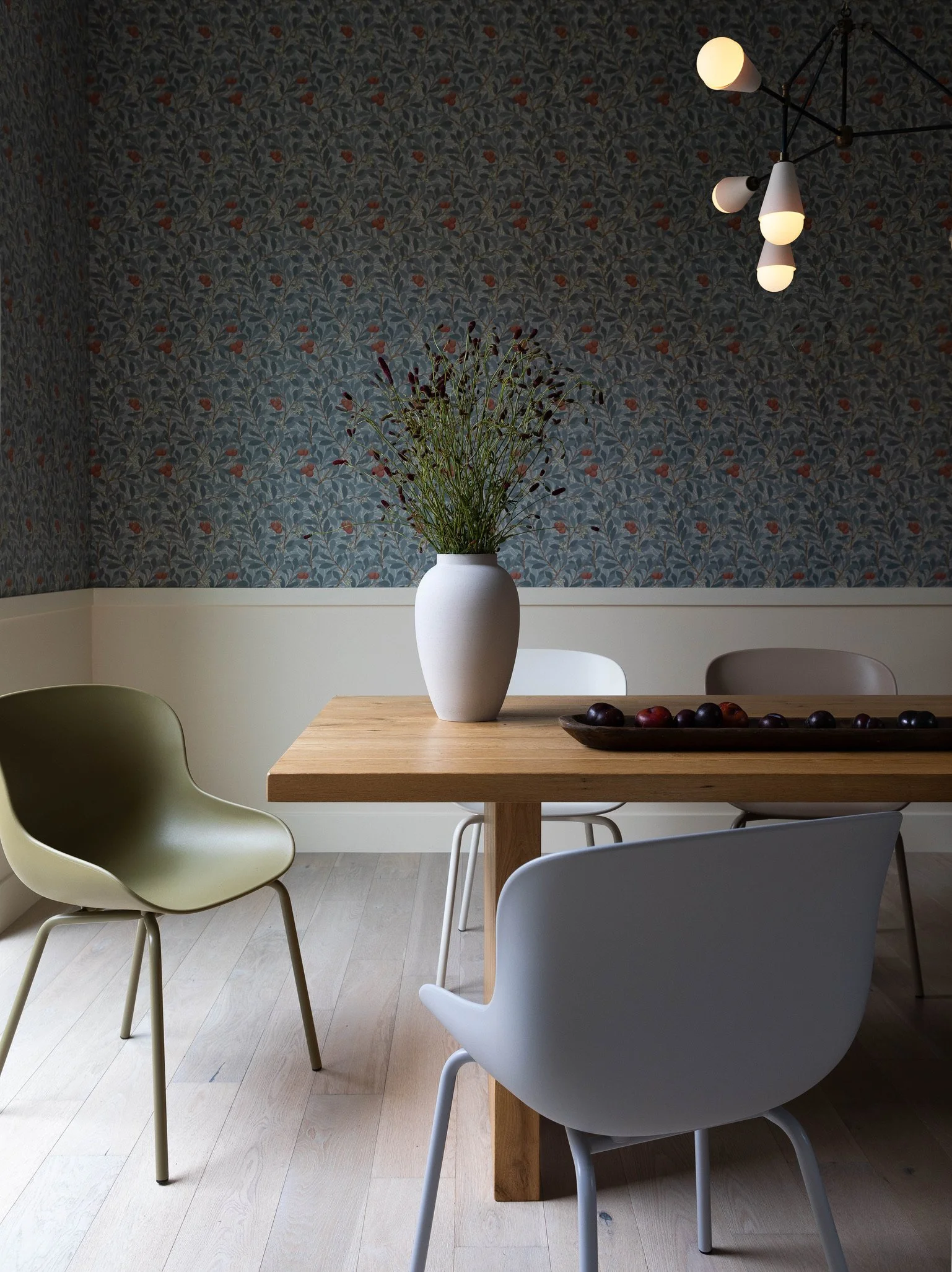 Los Angeles dining room with botanical wallpaper, modern furniture, statement lighting and warm natural wood.
