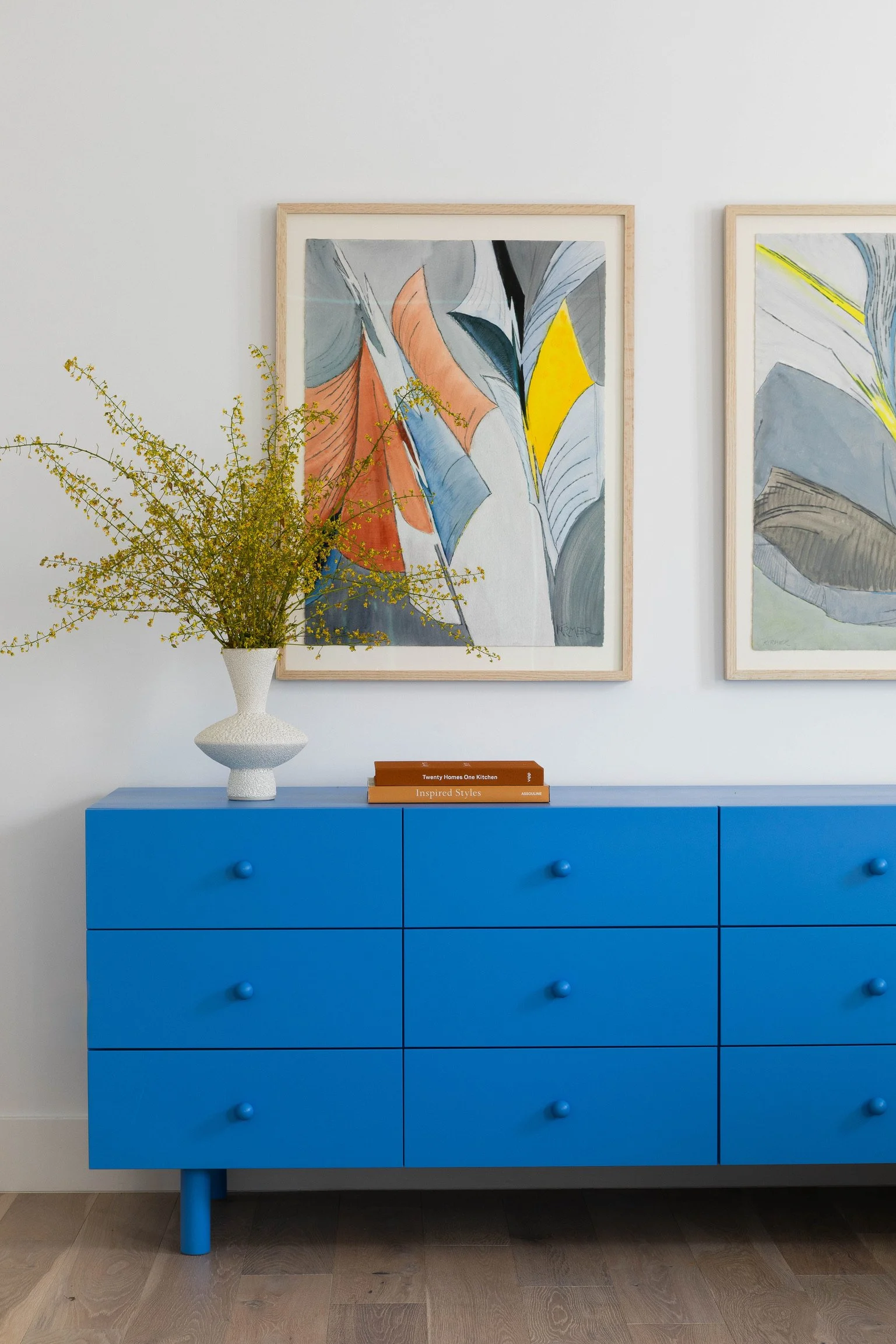 Los Angeles primary bedroom with bold blue dresser, contemporary artwork and curated modern decor.