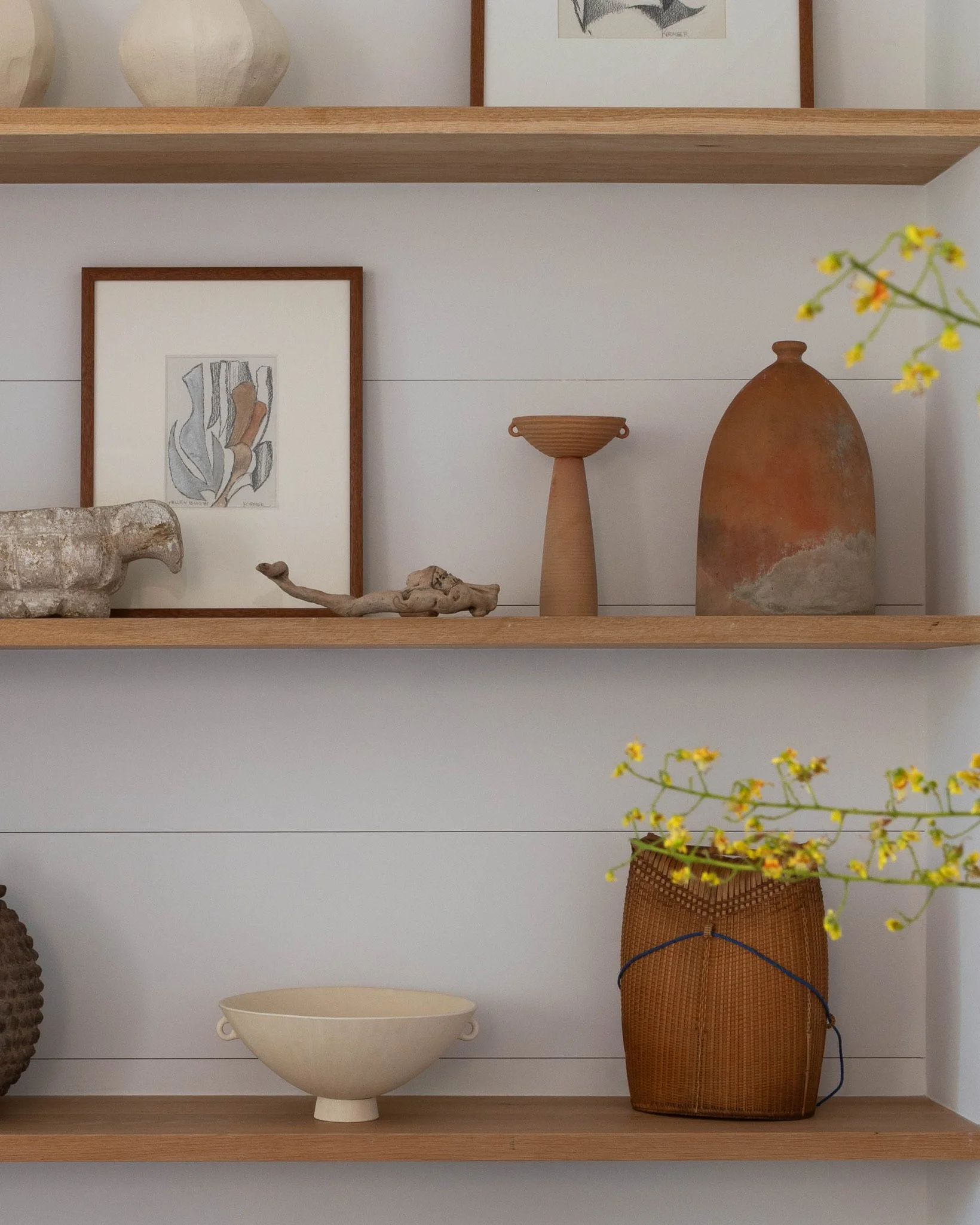 Los Angeles modern interior with custom floating wood shelves, curated artwork, sculptural ceramics and natural textures.