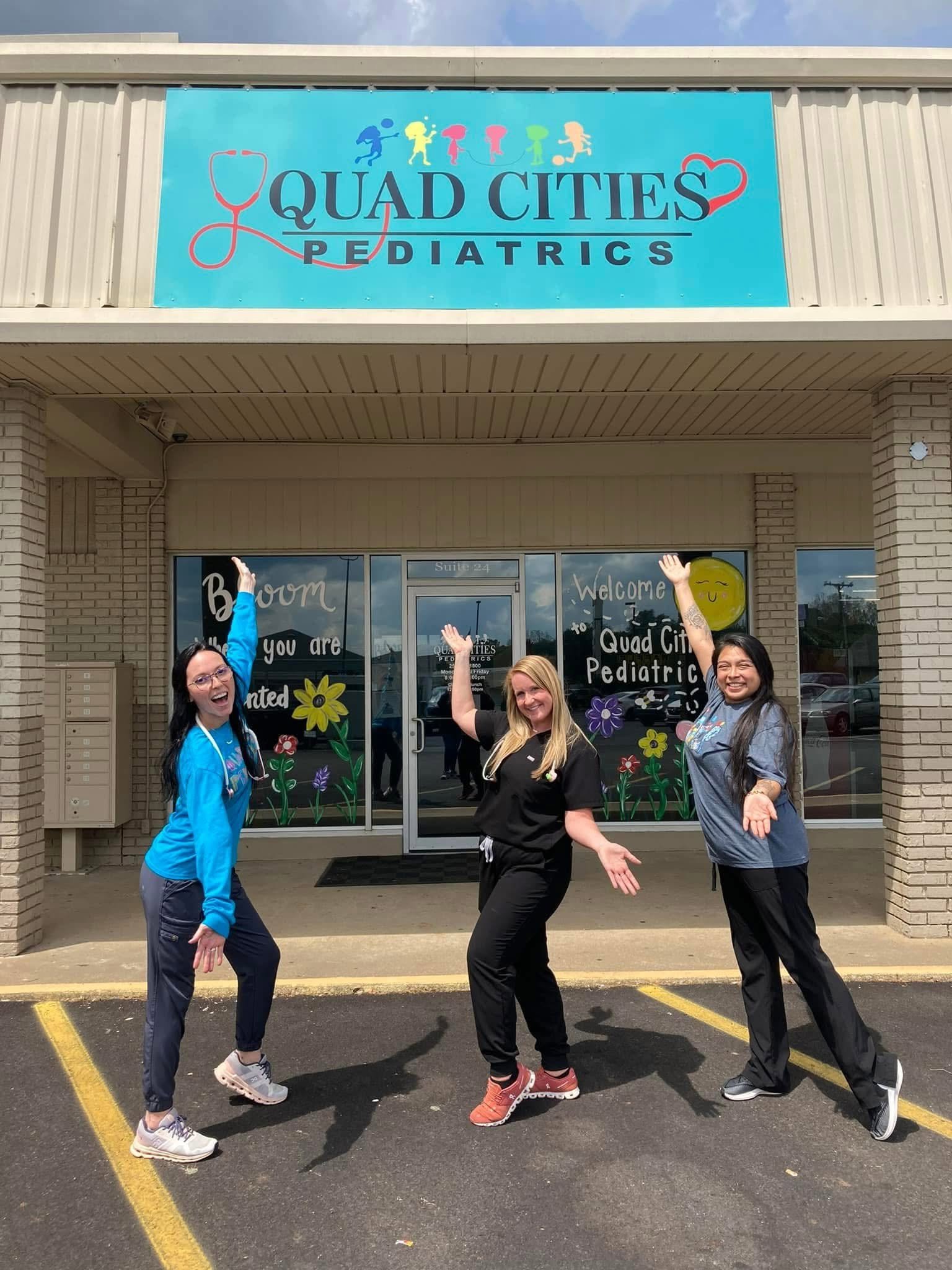 Staff standing in front of Quad Cities Pediatrics sign