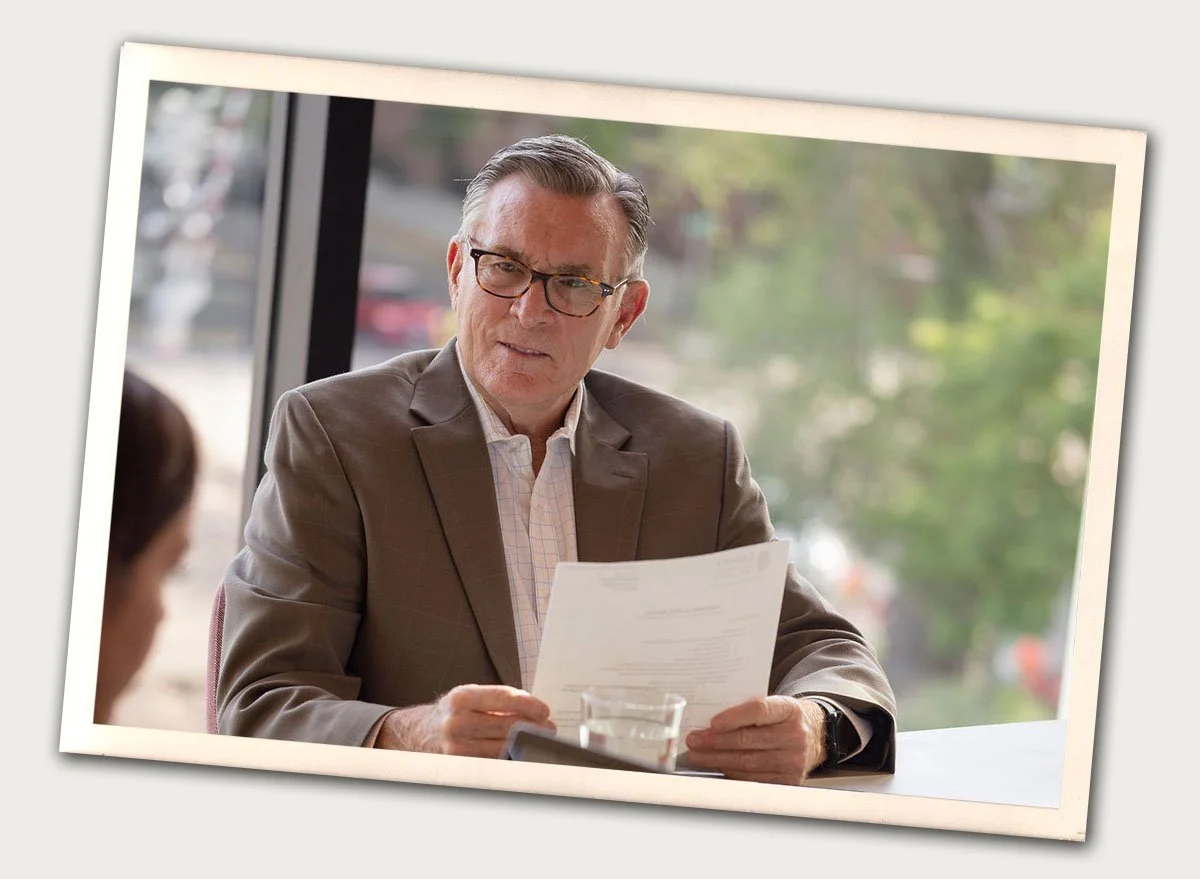 close shot of professional older man talking to someone casually in a meeting