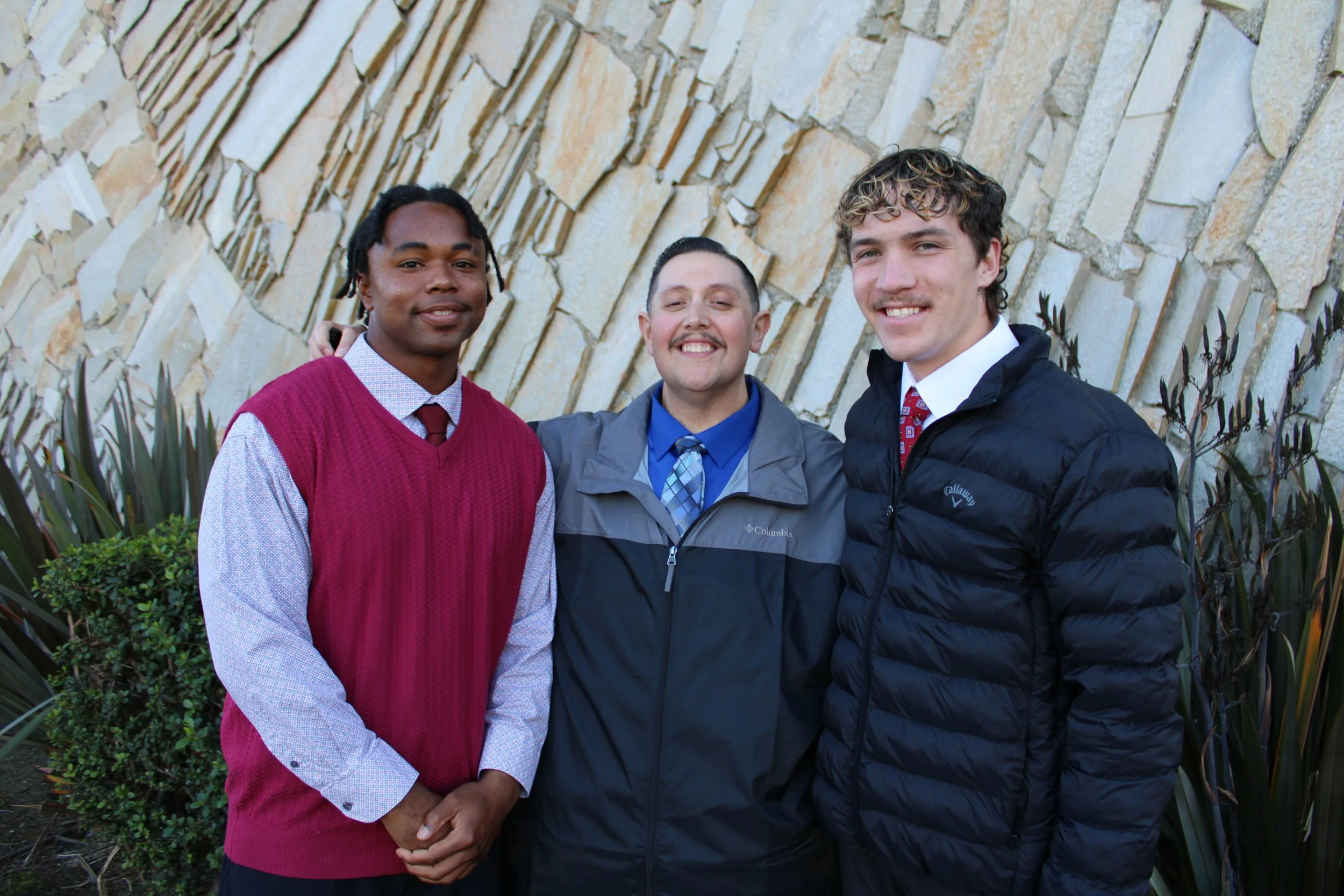 two teen boys sitting at table in a sunny park 