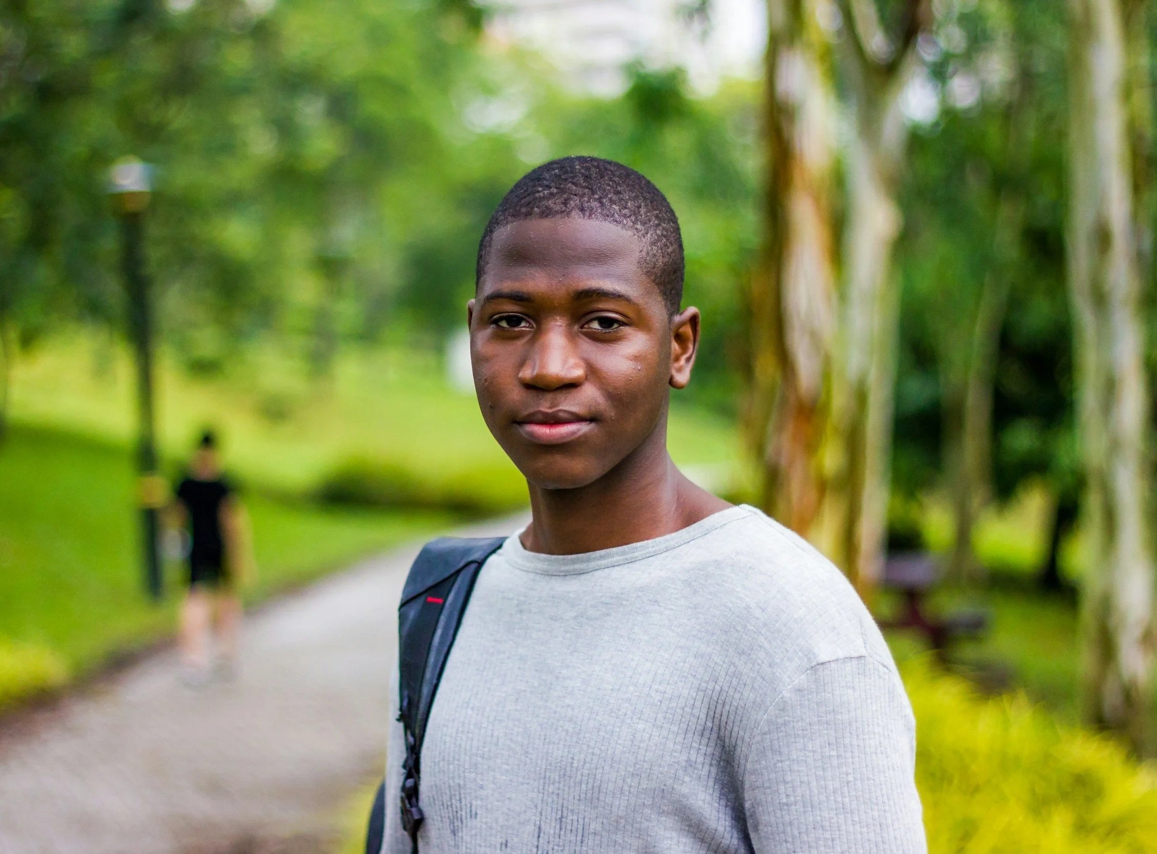 two teen boys sitting at table in a sunny park