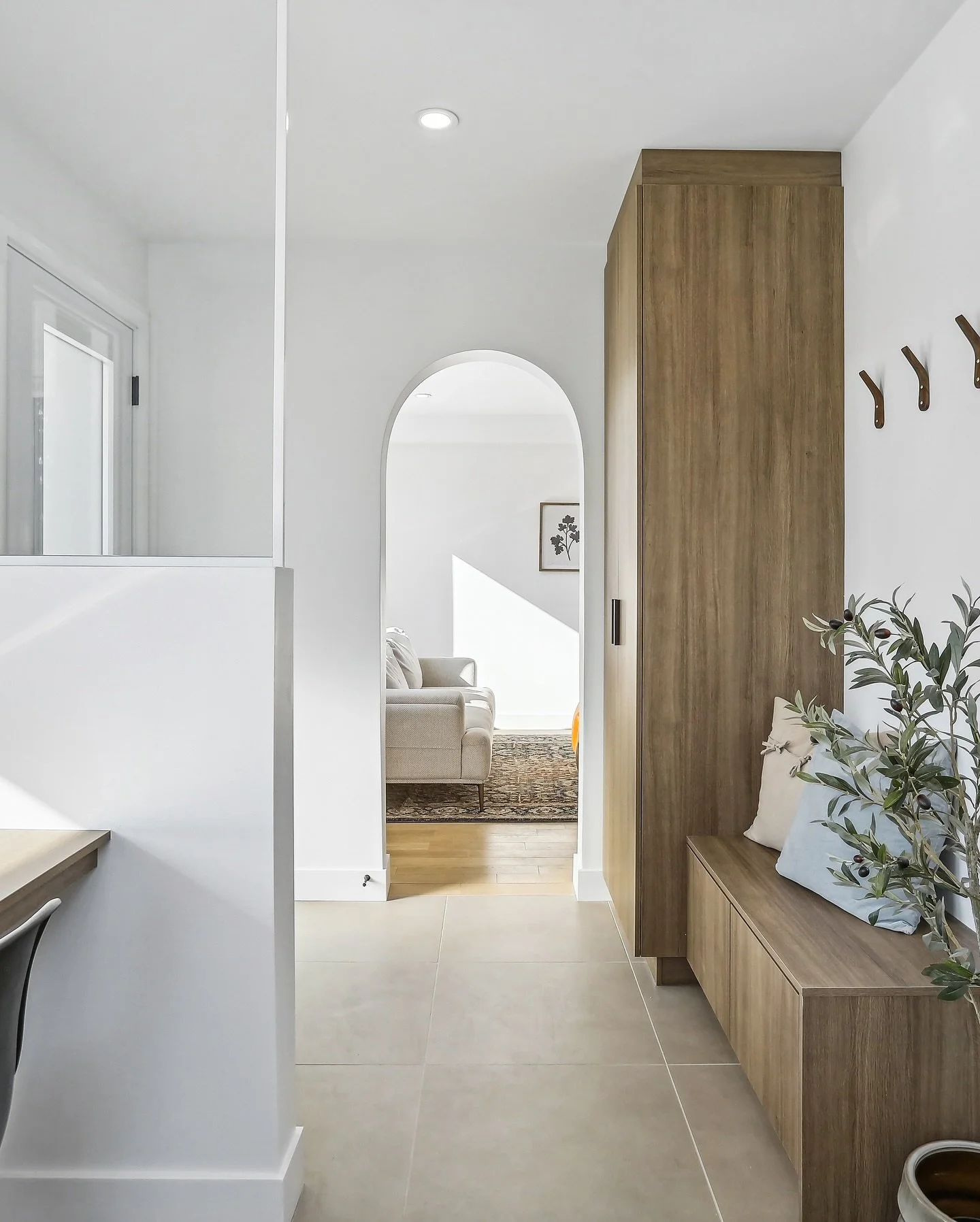 Voici une entr&eacute;e au design &eacute;l&eacute;gant et fonctionnel. Des mat&eacute;riaux chaleureux et un aspect pratique cr&eacute;ent une ambiance accueillante. L&rsquo;arche menant au salon ajoute une touche charmante que l&rsquo;on adore. Off