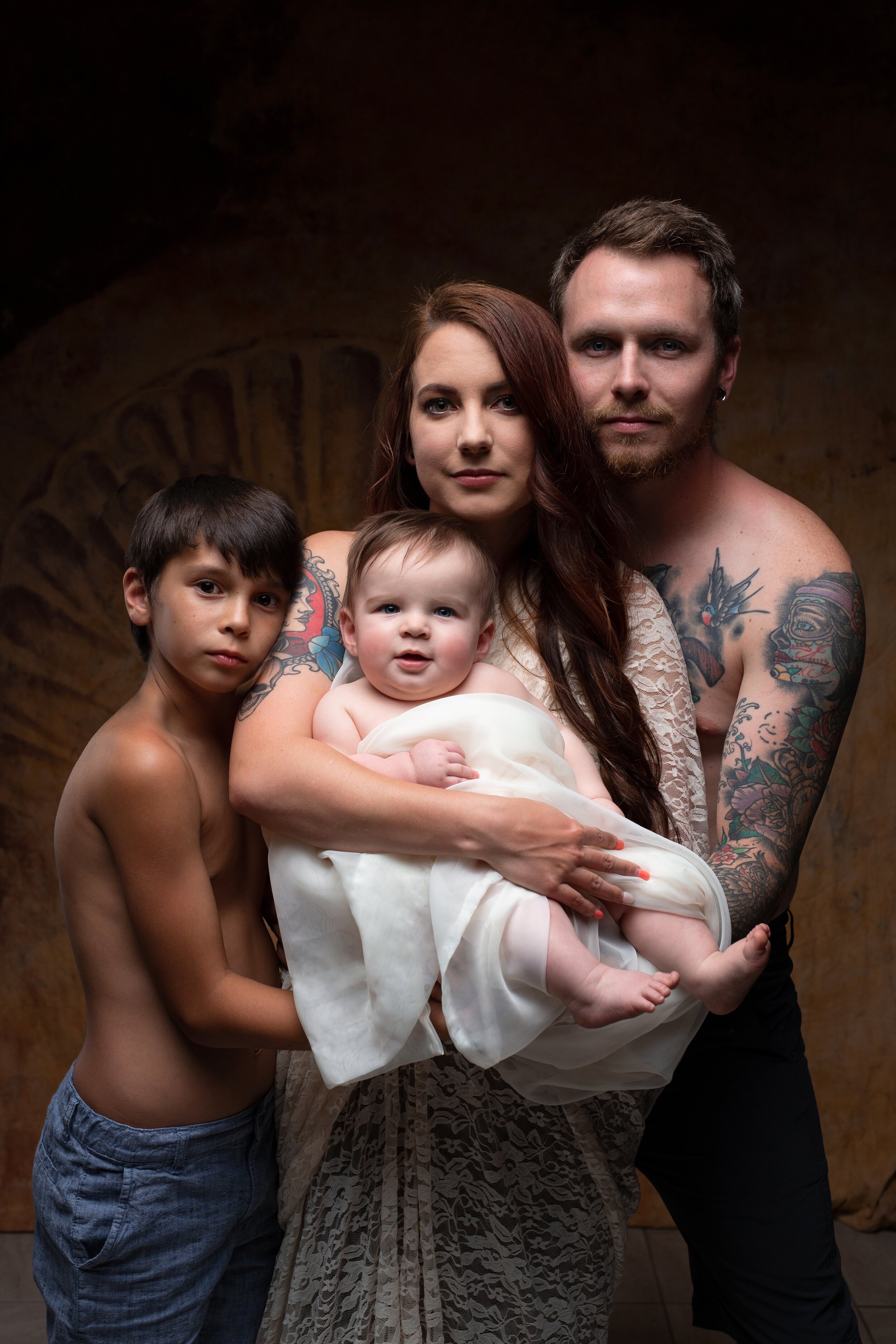 Dramatic family photo with mom and dad and their two sons in a Laurel, MT studio near Billings