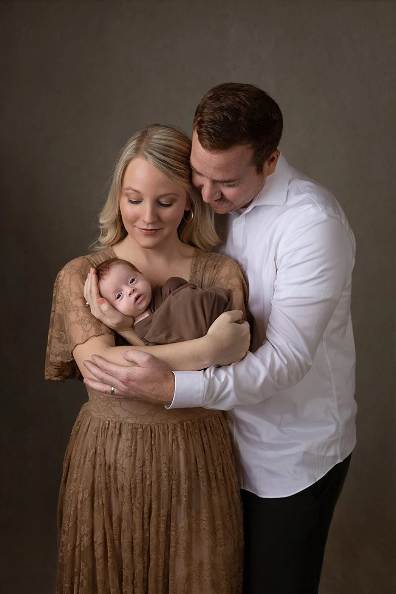 Mom and dad holding baby for family photos near Billings, Montana