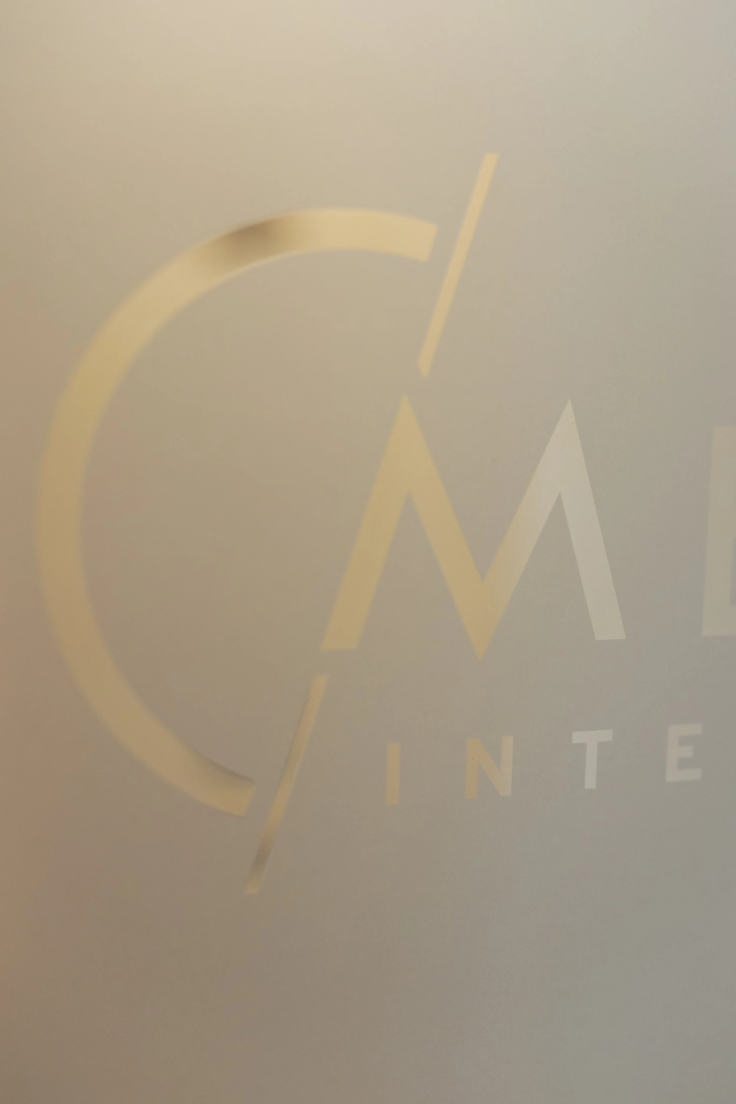 A close-up of a logo with a circular yellow outline, containing stylized white text that reads 'CLINTE,' on a gray background.