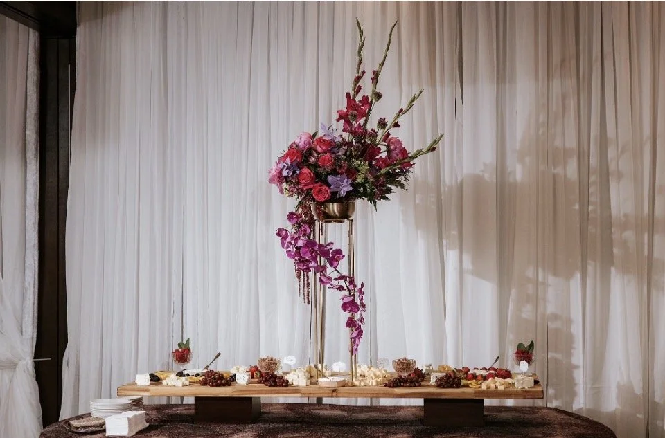 A tall centerpiece in the middle of a table for a birthday party.