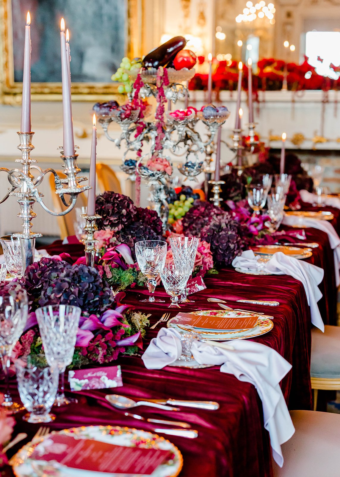 A tablescaped with produce, flowers, and nude taper candles.