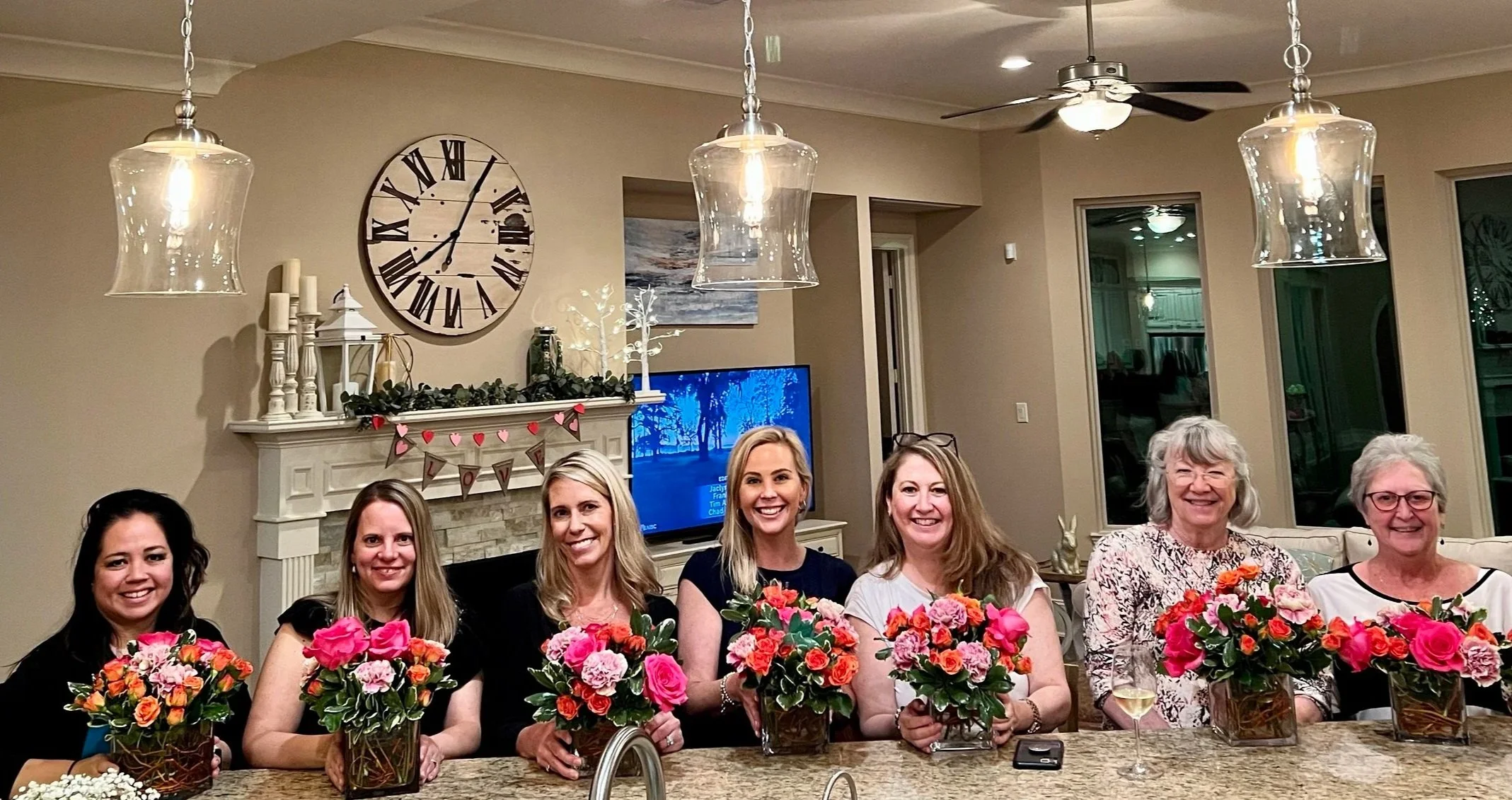 A group of ladies with their finished arrangements led by Fashionable Florist.
