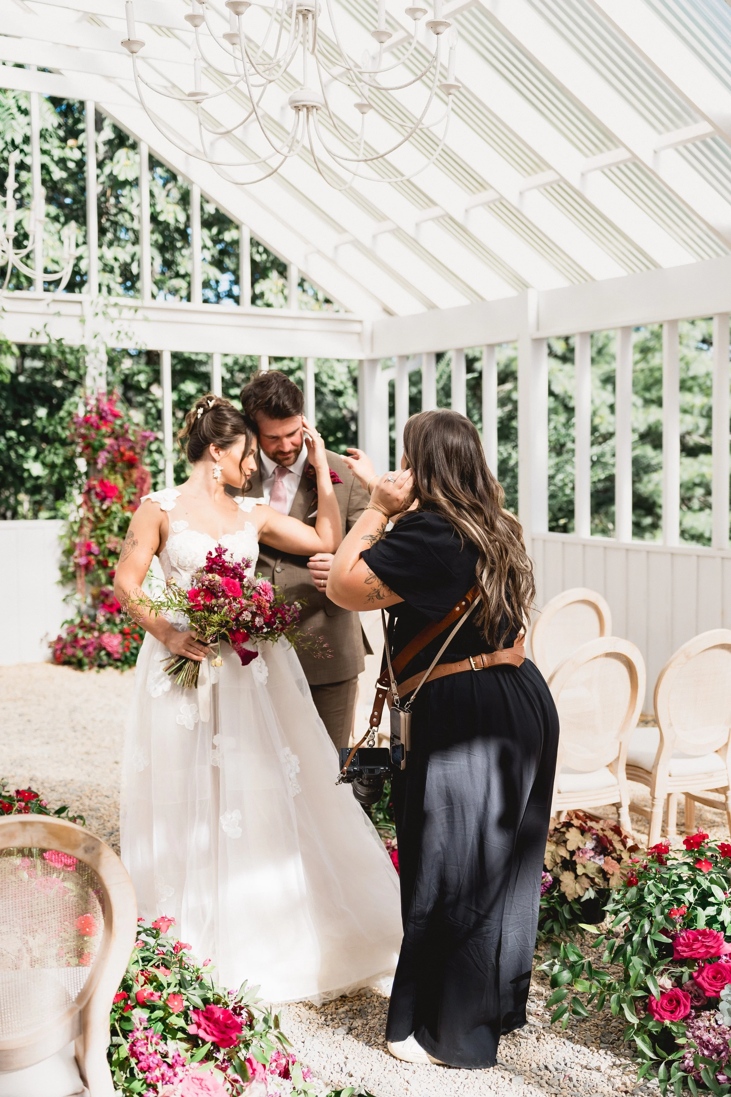 A couple with a photographer being positioned for their photos.