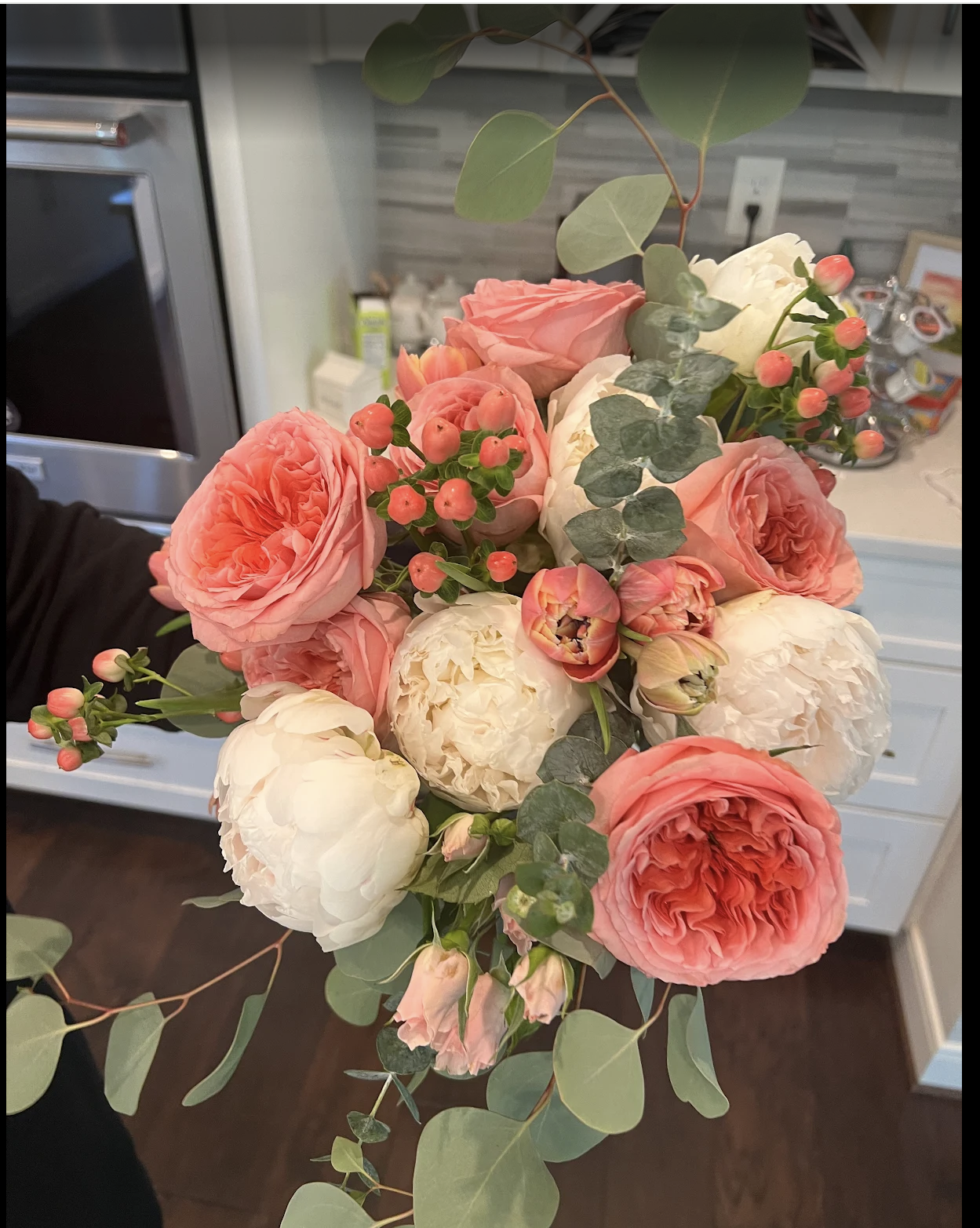 Client of Fashionable Florist is showing off her hand-tied bouquet.