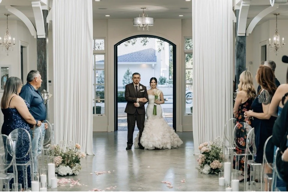 Bride walking down the aisle adorned with pillar candles.