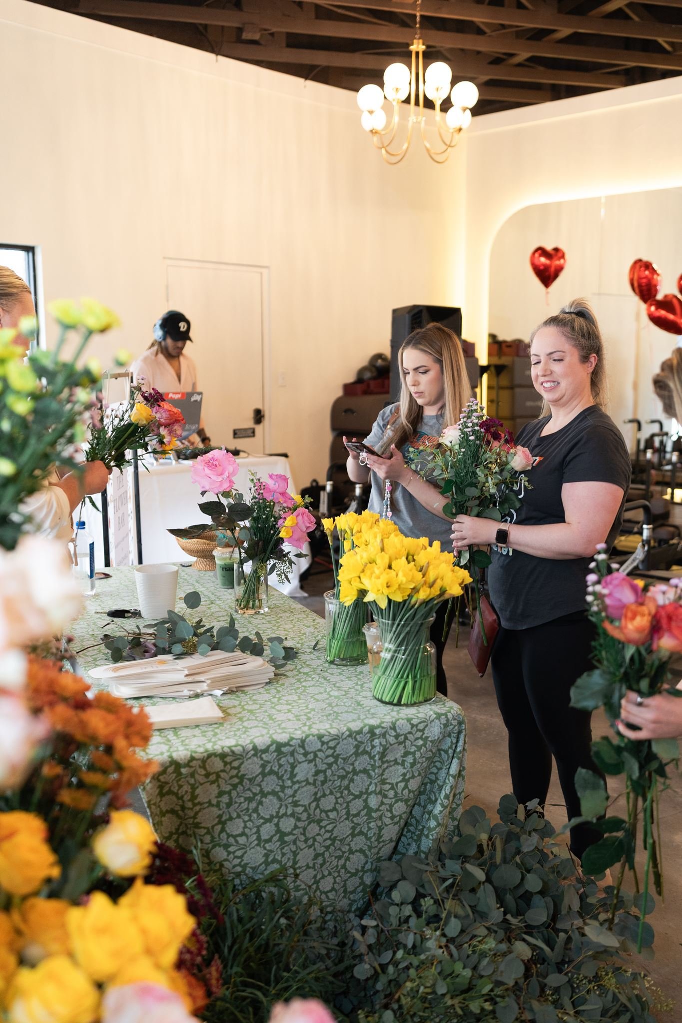 Guests standing at a table, admiring their flower bouquet they just made.