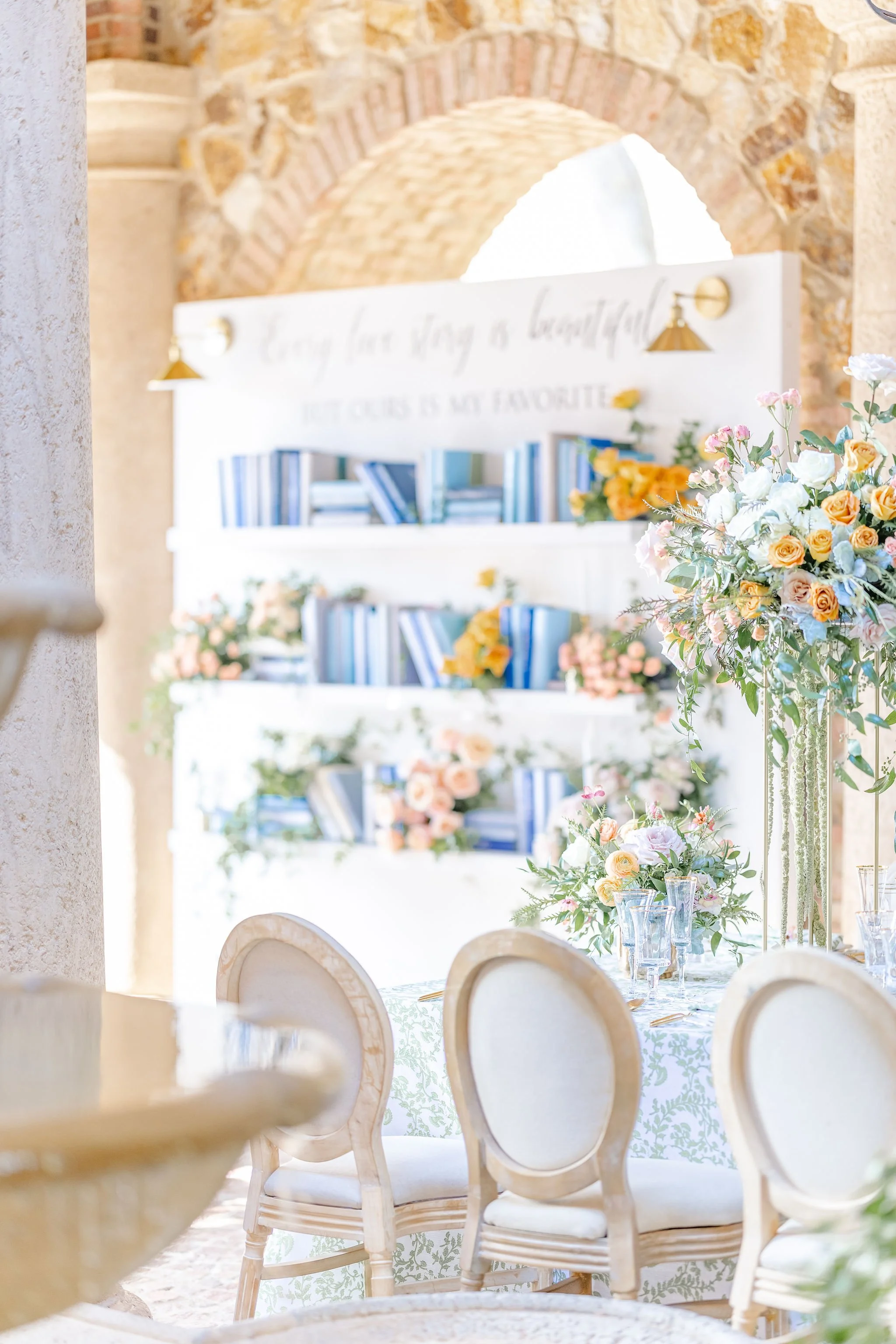 A book shelf lined with blue books to create an escort card  area for guests.
