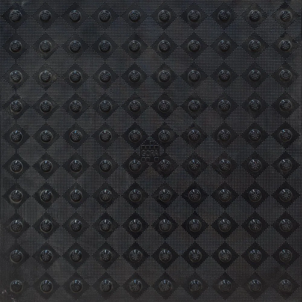 Product close-up of the GORA 24x24" (610x610mm) onyx black fiberglass tactile plate.