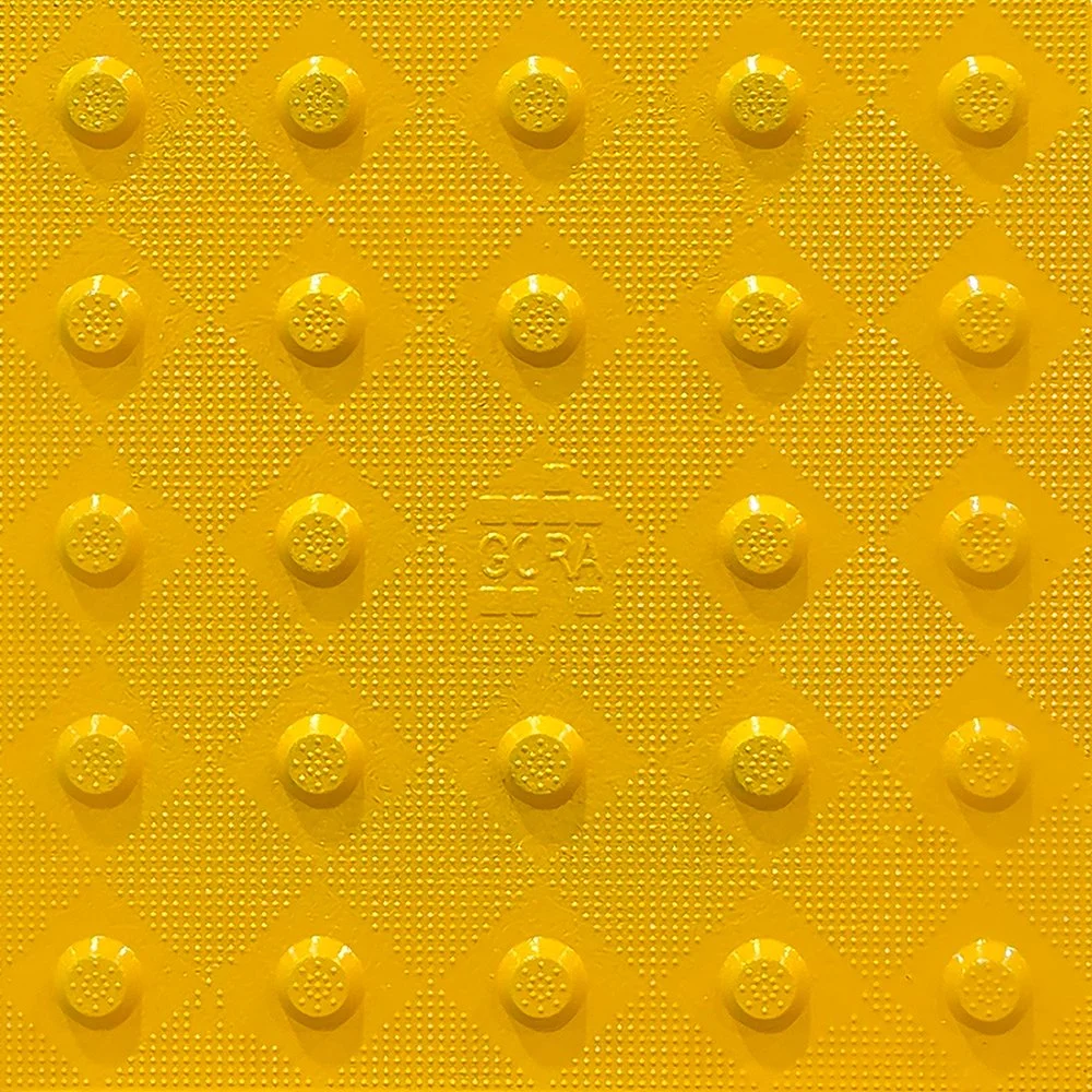 Product close-up of the GORA 12x12" (305x305mm) safety yellow fiberglass tactile plate.