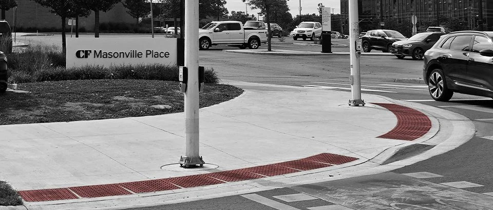 Pedestrian crossing with GORA brick red steel tactile and radial plates at the traffic intersection in front of Masonville Place Shopping Mall.
