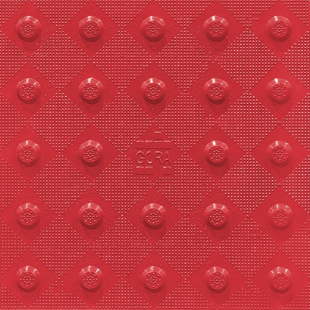 Product close-up of the GORA 12x12" (305x305mm) brick red fiberglass tactile plate.