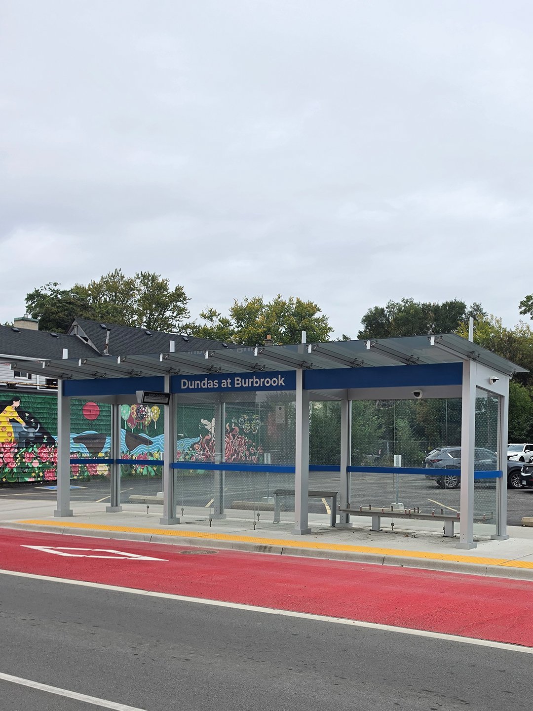 Dundas and Burbrook new bus shelter in London Ontario, with GORA 24x24" safety yellow fiberglass tactile plates embedded into the concrete between the bus platform and the road.