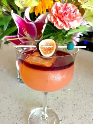 Figgin drink. House made fig and ginger syrup. Sweet bourbon drink topped with cabernet. Fan favorite. Loved by all. one of a kind cocktails. Beautiful cocktail glasses.