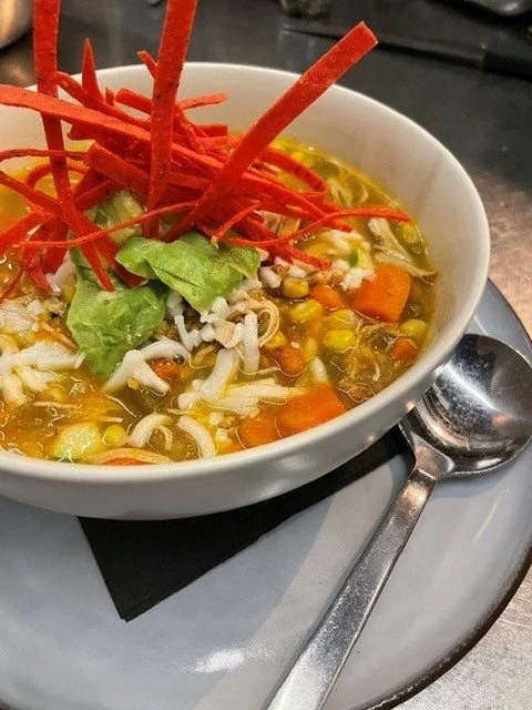 Seasonal tortilla soup. hot chicken soup. Warm up during cold weather. Fresh made from scratch tortilla soup. limited time. authentic chicken tortilla soup. clear broth tortilla soup. topped with avocato and grilled sweet corn.
