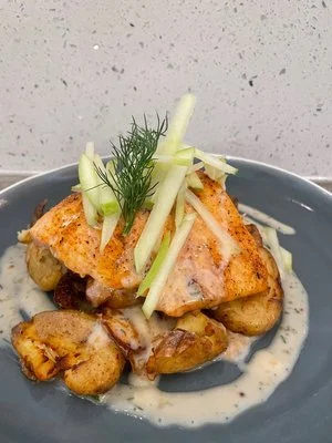 Fresh Scottish Salmon with a lemon dill butter sauce, beurre blanc, served with crushed potatoes, fresh herbs, and apple slices.