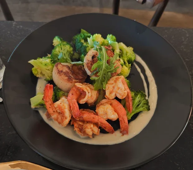 Fresh Seafood dish with grilled scallops, sauteed shrimp, and broccoli. Fresh catch. dietary restrictions compatible. Allergen free vegetables. gluten free options. gluten free fries. gluten free desserts. elevated dining experience. lobster tail.
