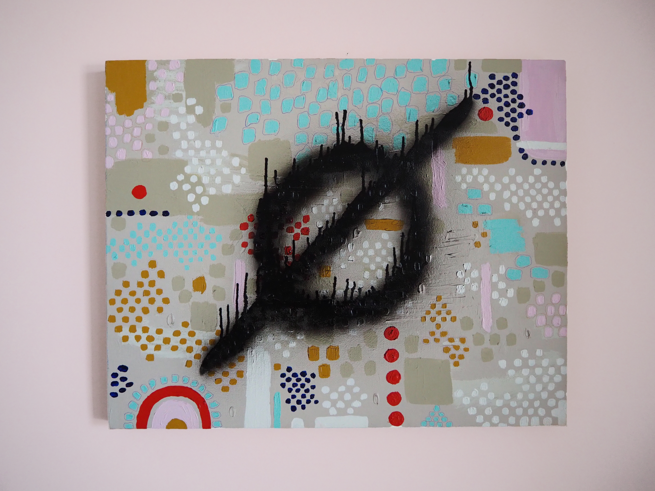 Abstract painting with black spray-painted eye-shaped figure over a background of colorful dots and shapes