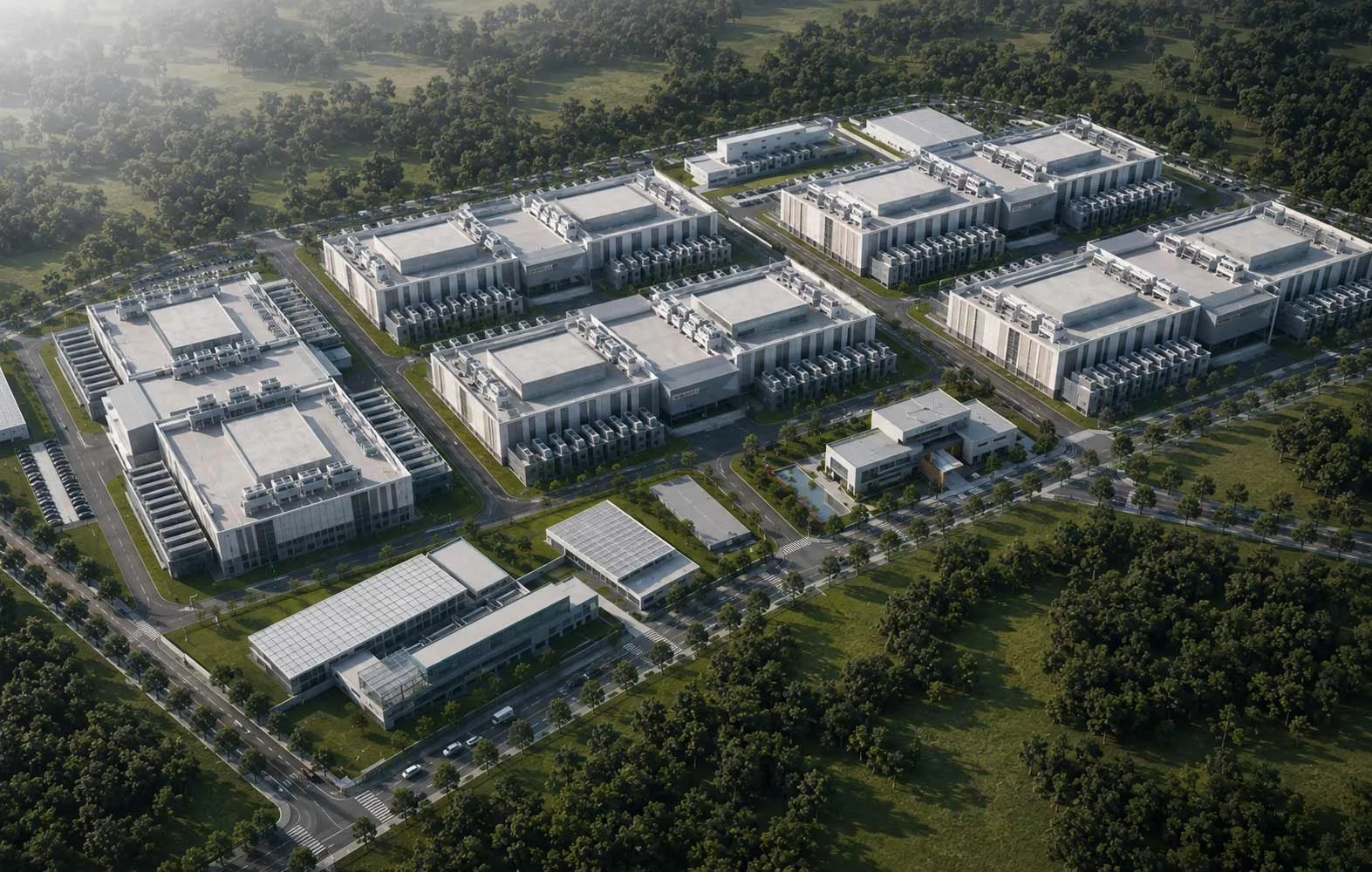 Aerial view of Silicon Tech Park's modern campus or business complex with multiple large white buildings, parking lots, and landscaped green areas surrounded by trees.