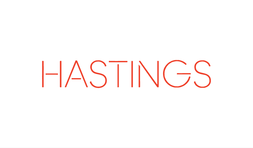 Red neon sign spelling 'HASTINGS' on a black background.
