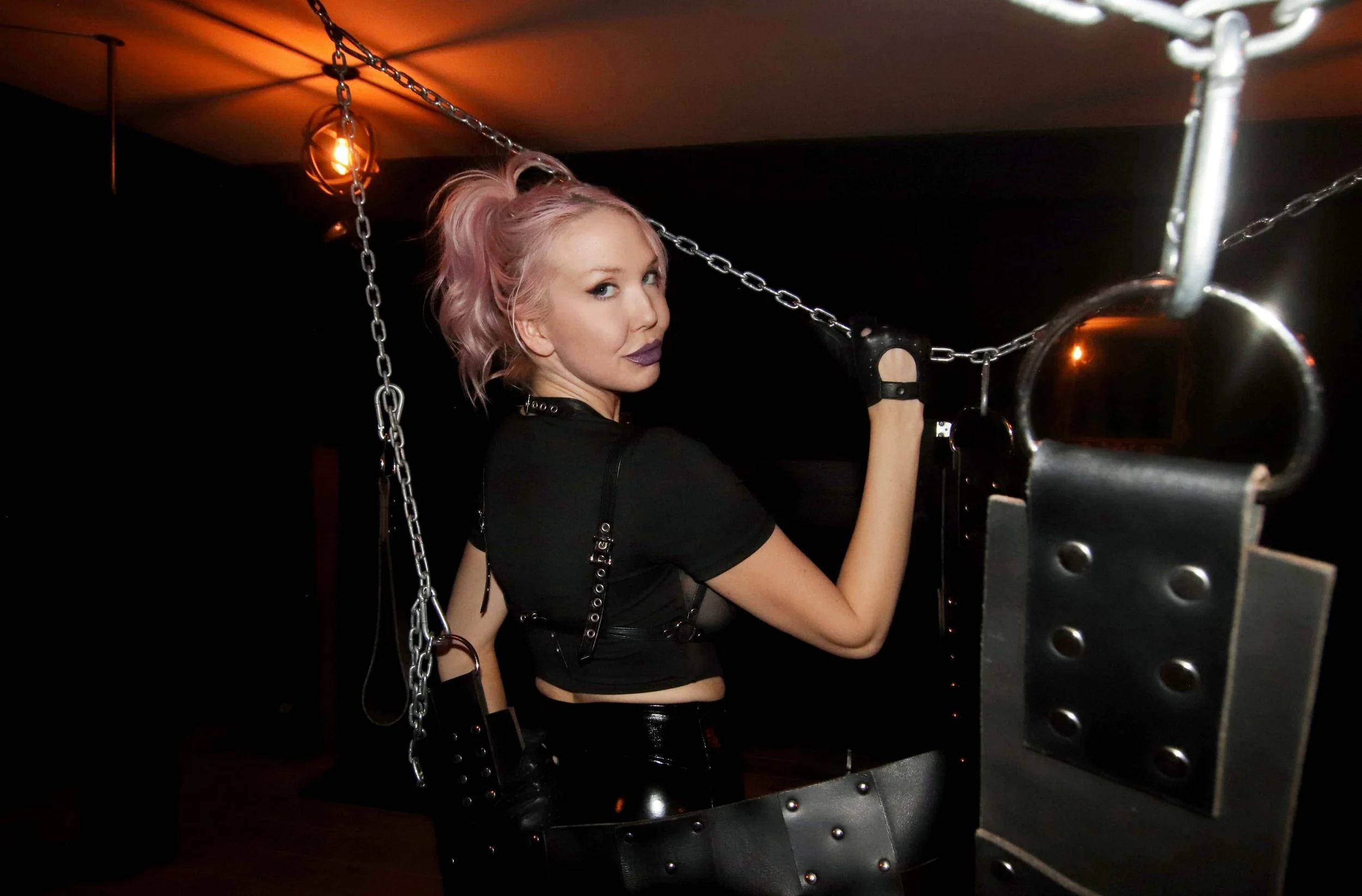 Toronto Dominatrix Ms Chloe Mars standing with a sex swing in a dungeon-min.JPG