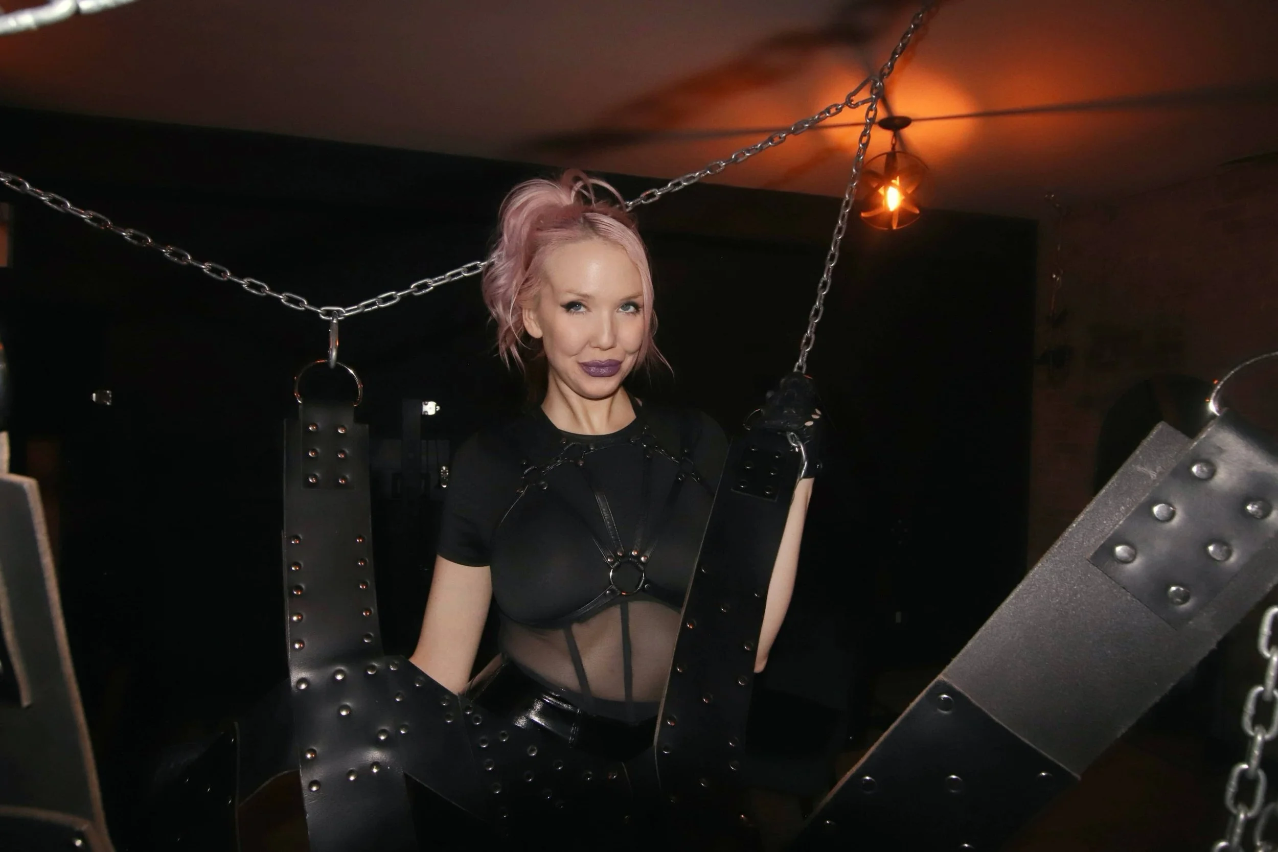 Toronto Pro-Domme Ms. Chloe Mars holding metal BDSM chains in dungeon-min.JPG