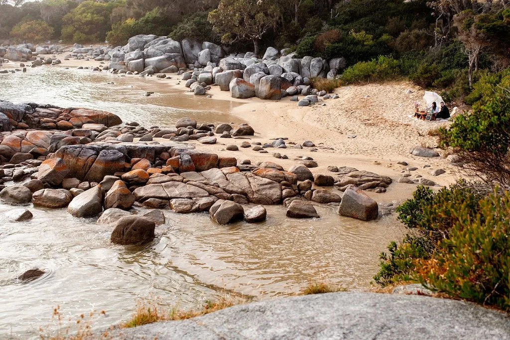 A couple enjoying a picnic in Binalong Bay after proposing.