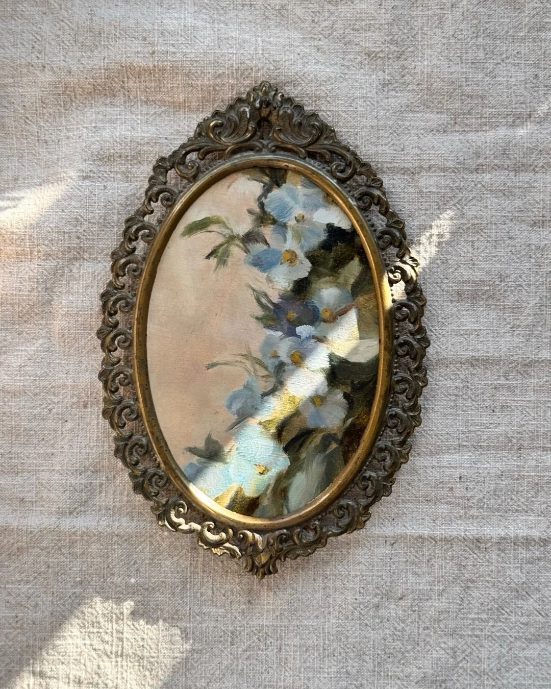 This painting was painted between collections.

A small oval of pale blue blossoms and passing afternoon light, somewhere between the skies and the roses, between spring fading and summer beginning.

The kind of piece that feels less like a statement