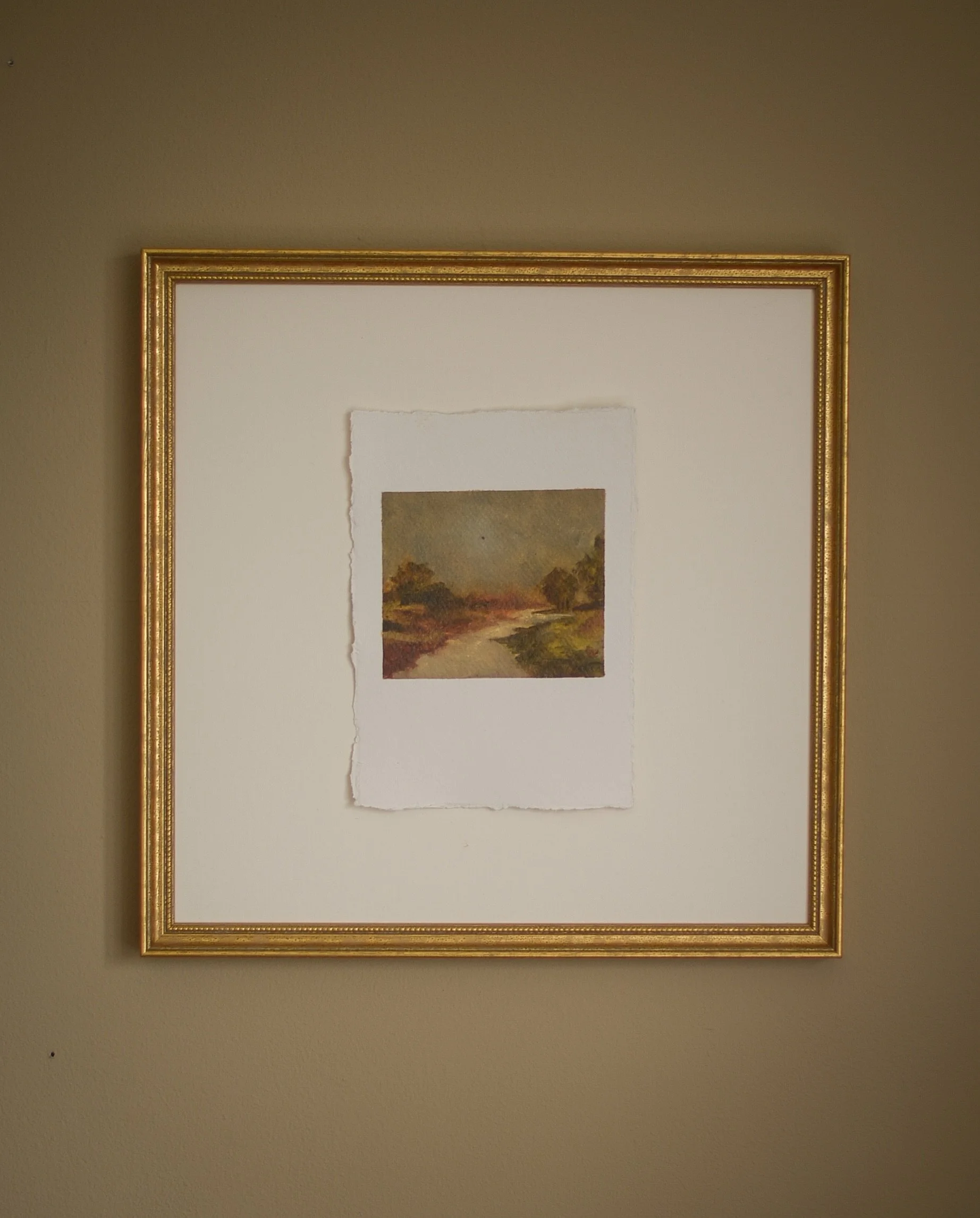 One of the smaller landscapes from The Way Home, shown here as a little framing inspiration.

I love the space around the painting. The wide mount allows the deckled edges to remain visible, while the warm gilded frame draws out the soft ochres, mute