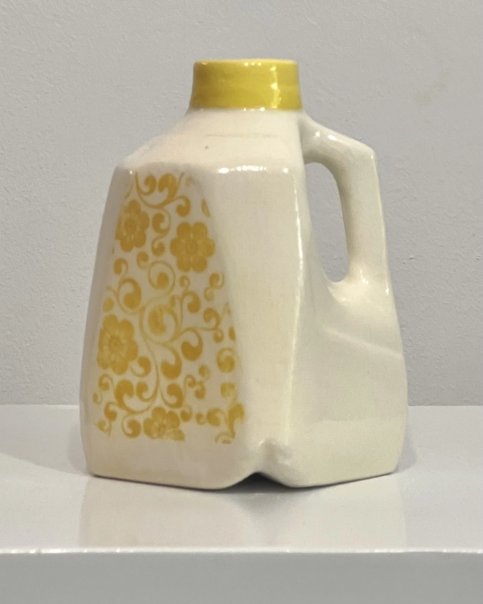 Handcrafted yellow floral porcelain milk jug with vintage-inspired floral transfer beneath a glossy clear glaze.