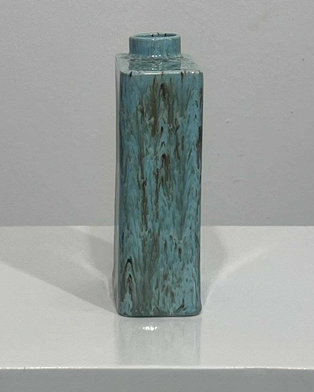 Narrow side view of porcelain carton vase showing vertical movement in Cenote glaze.