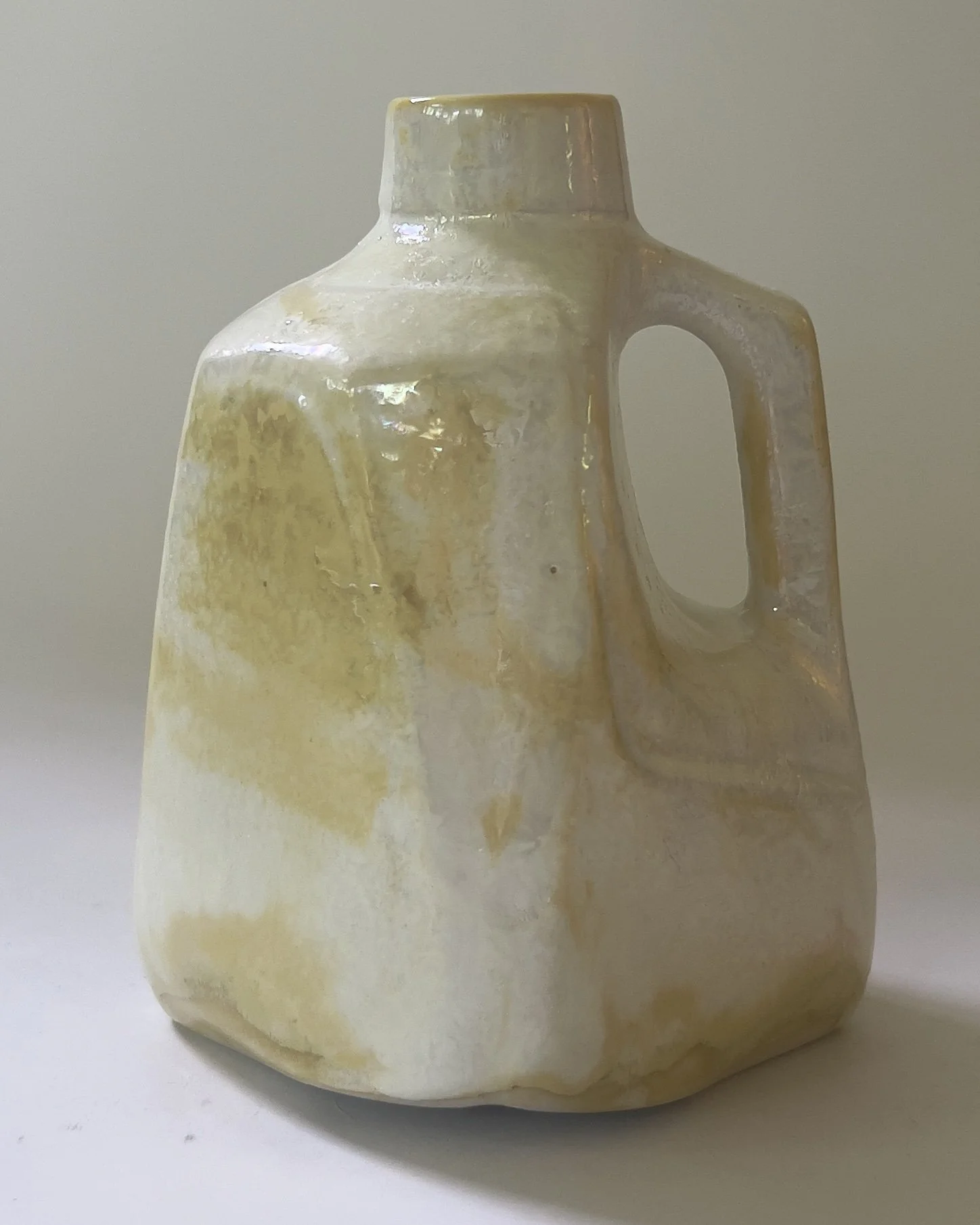 Iridescent ceramic milk jug vessel sculpture in pearly cream and soft gold glaze with angular handle