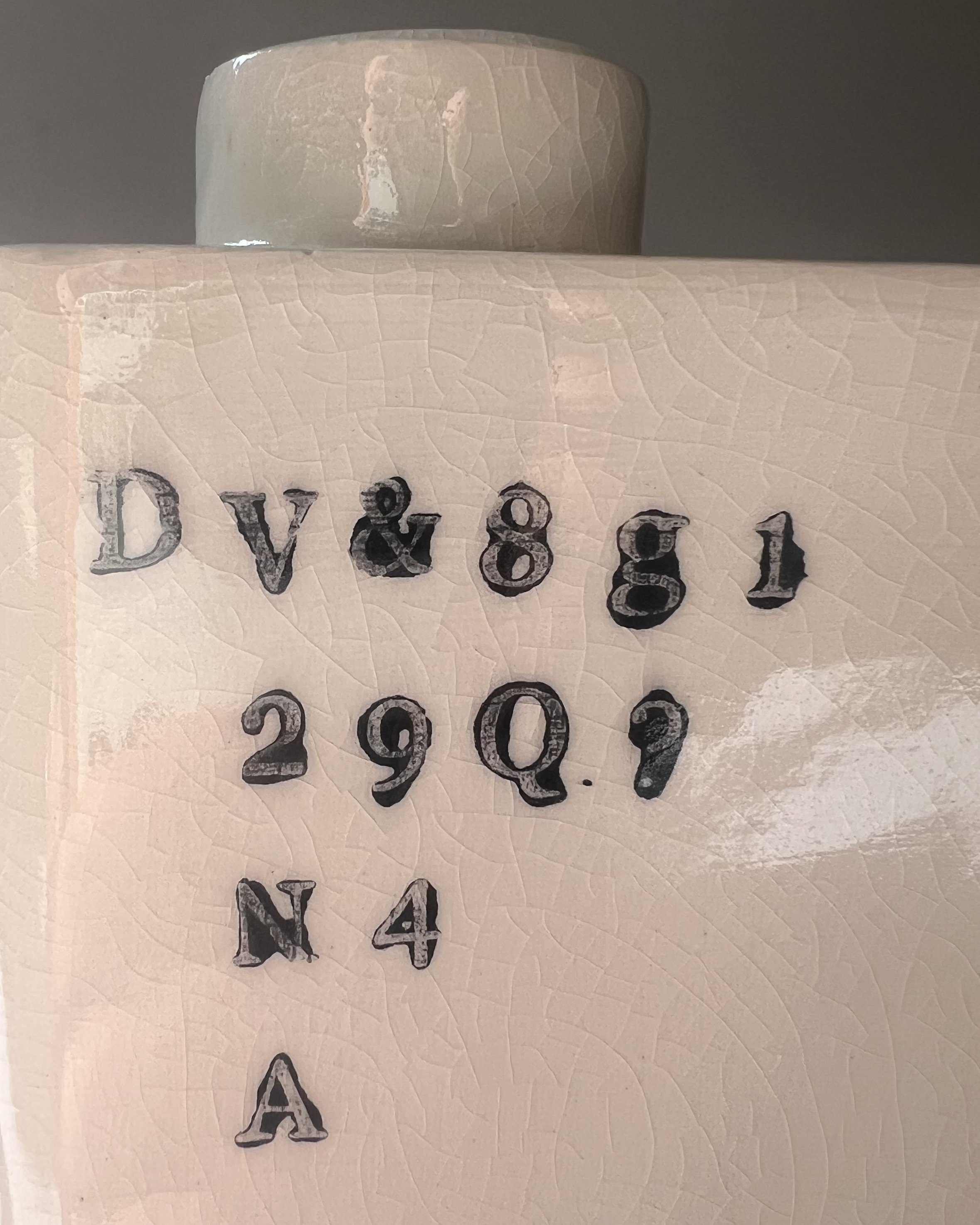 Close-up of impressed black typography on the surface of a handbuilt porcelain milk carton.
