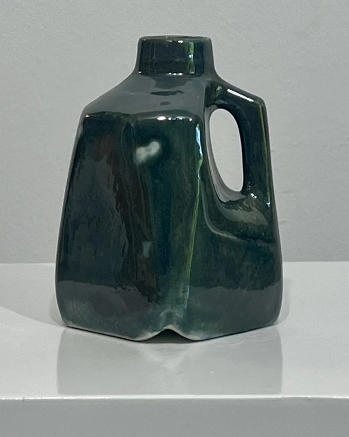 Front view of handmade porcelain milk jug vase glazed in Vintage Gold over Rainforest, featuring layered green, charcoal, and bronze glaze effects.